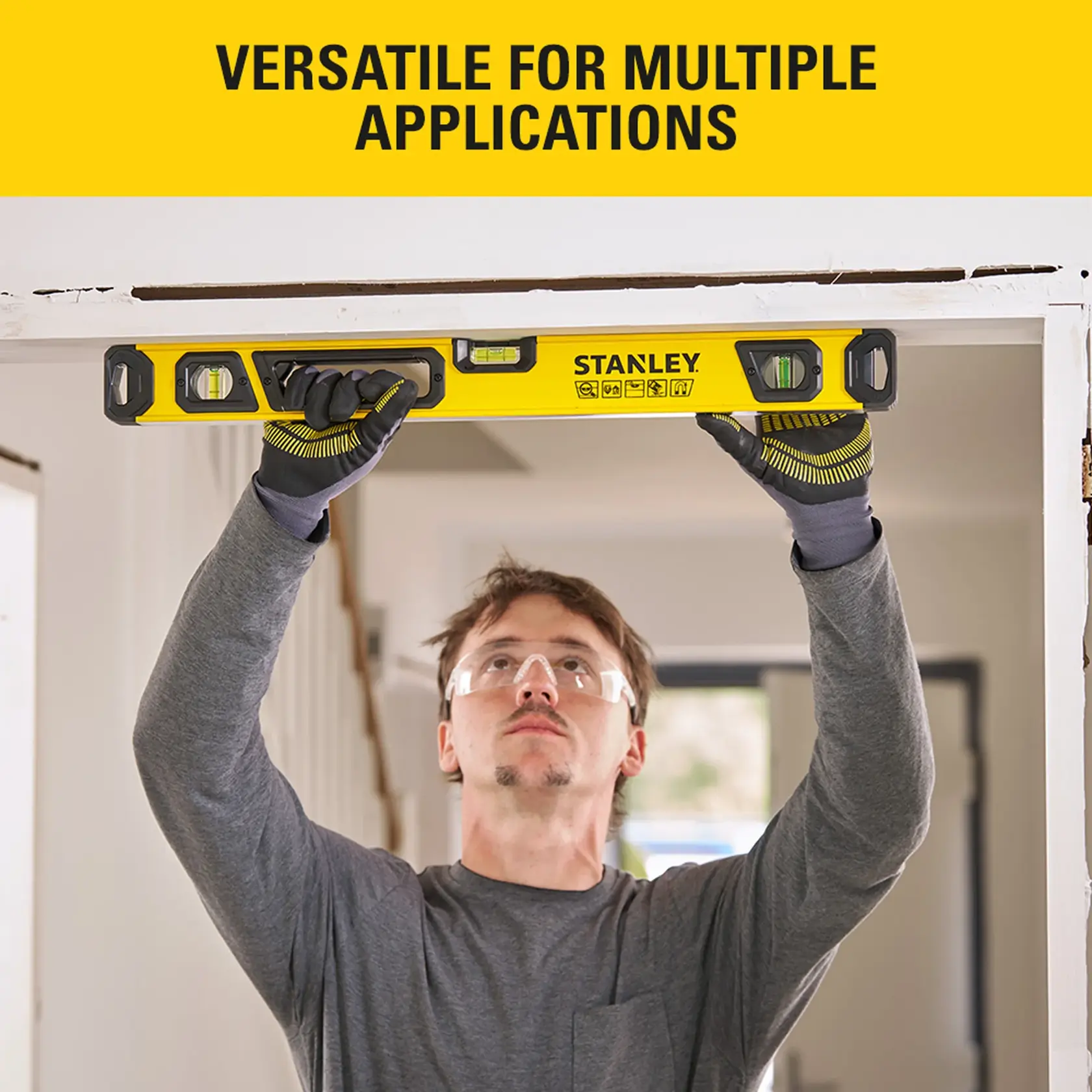 Photo of person using STANLEY STHT41724-0 spirit level to check door frame alignment indoors.