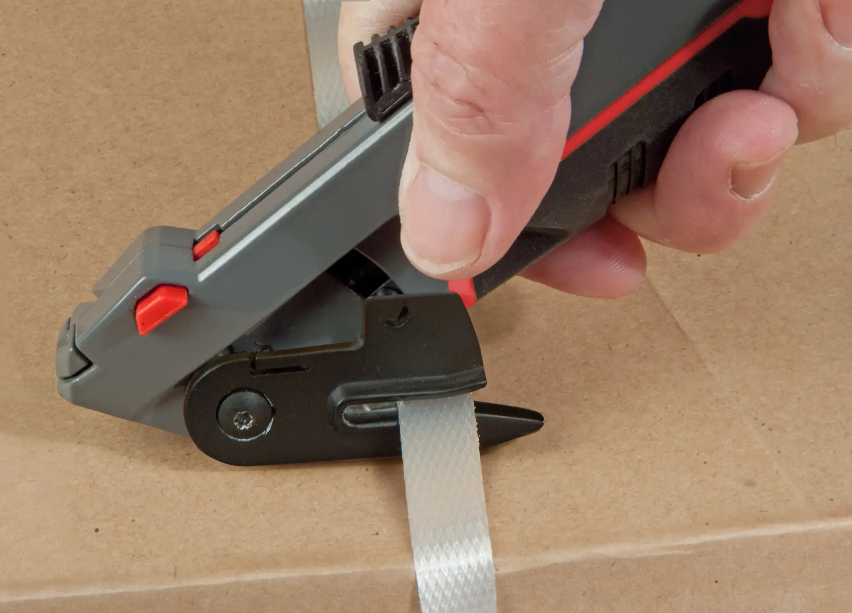 STANLEY 0-10-242 photography of hand-held strap cutter tool on cardboard box.