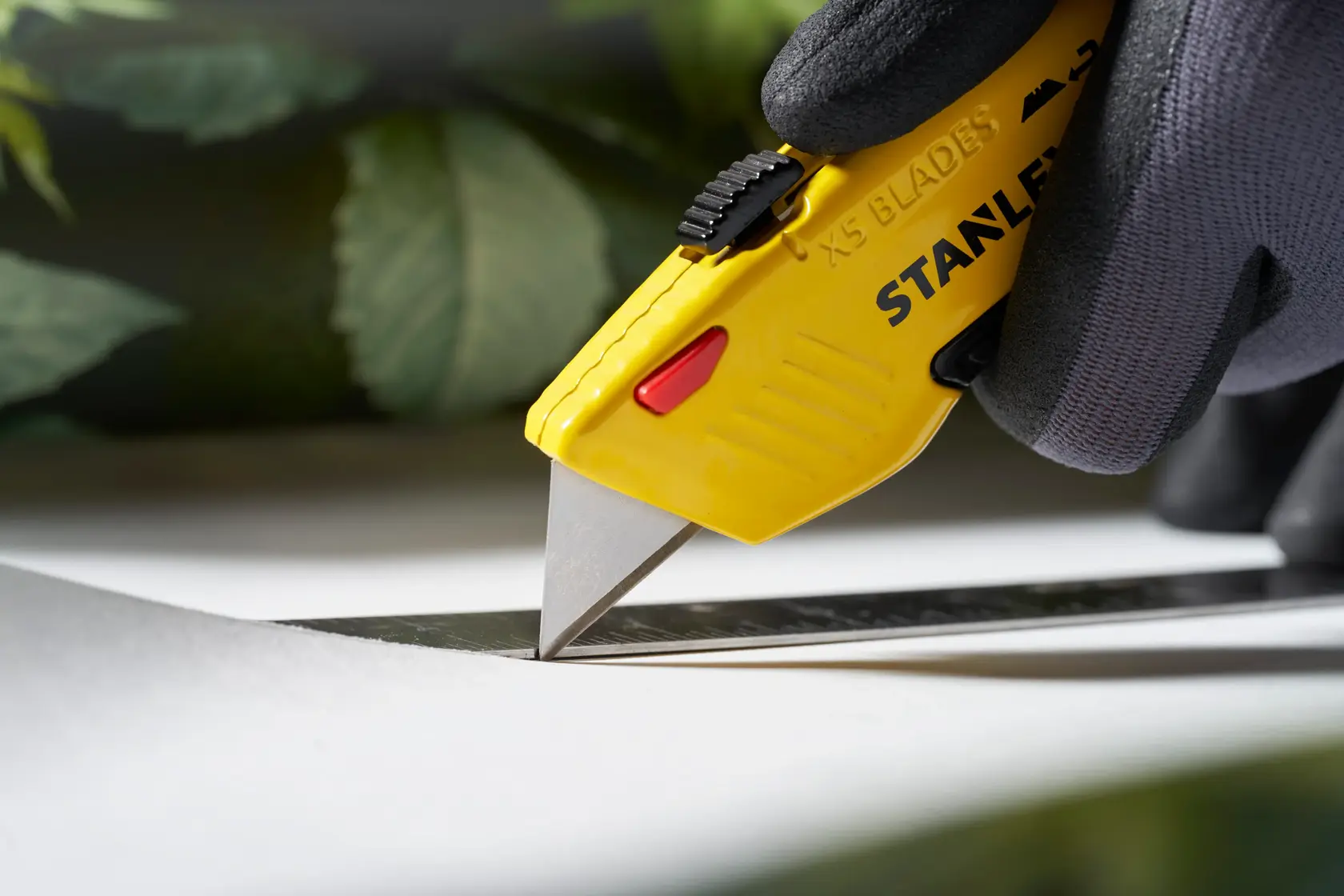 Stanley 0-11-921 utility knife photo shows yellow casing and blade cutting along a metal ruler.