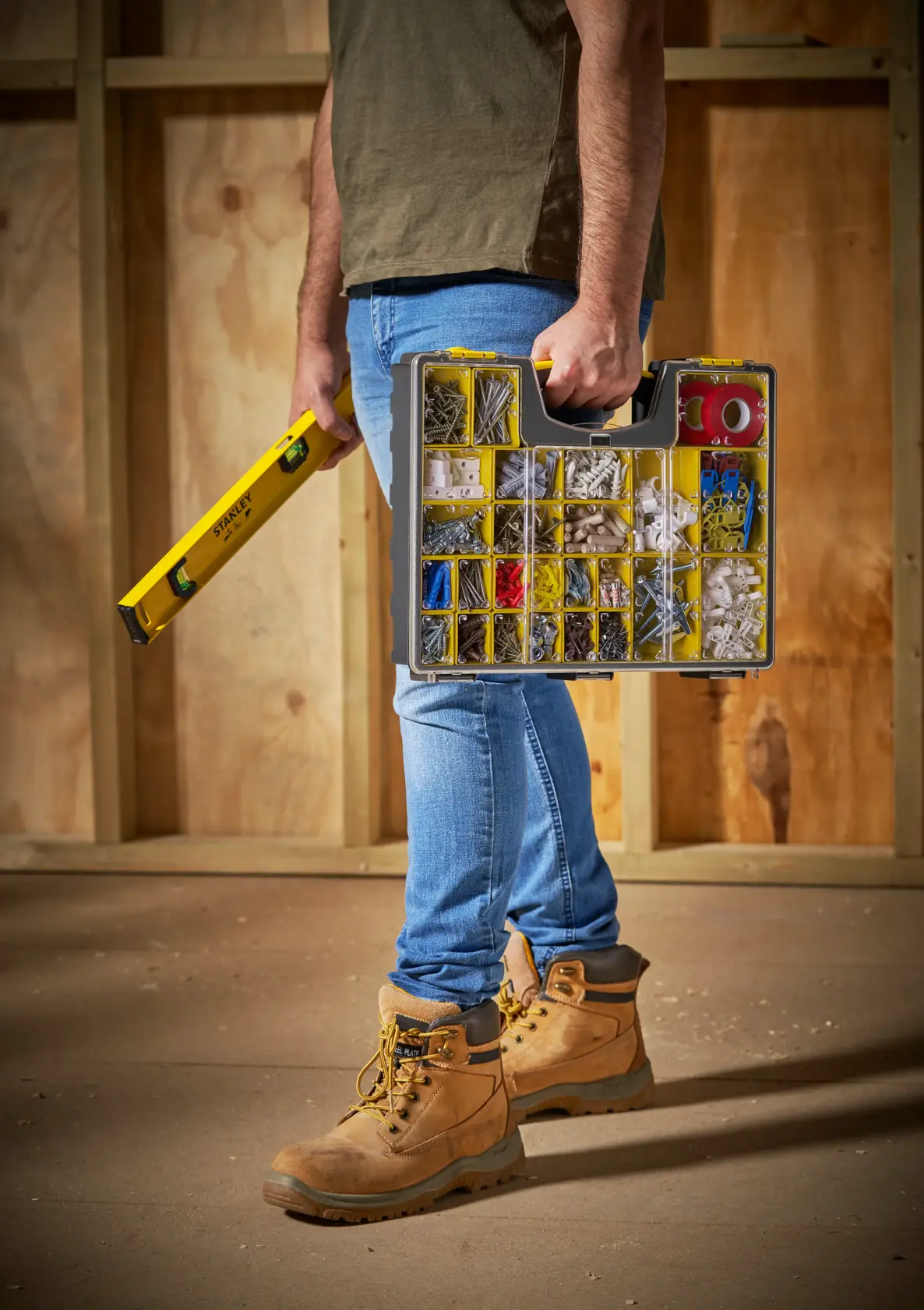 STANLEY 1-92-748 organizer box with assorted fasteners, carried beside yellow level tool at construction site.