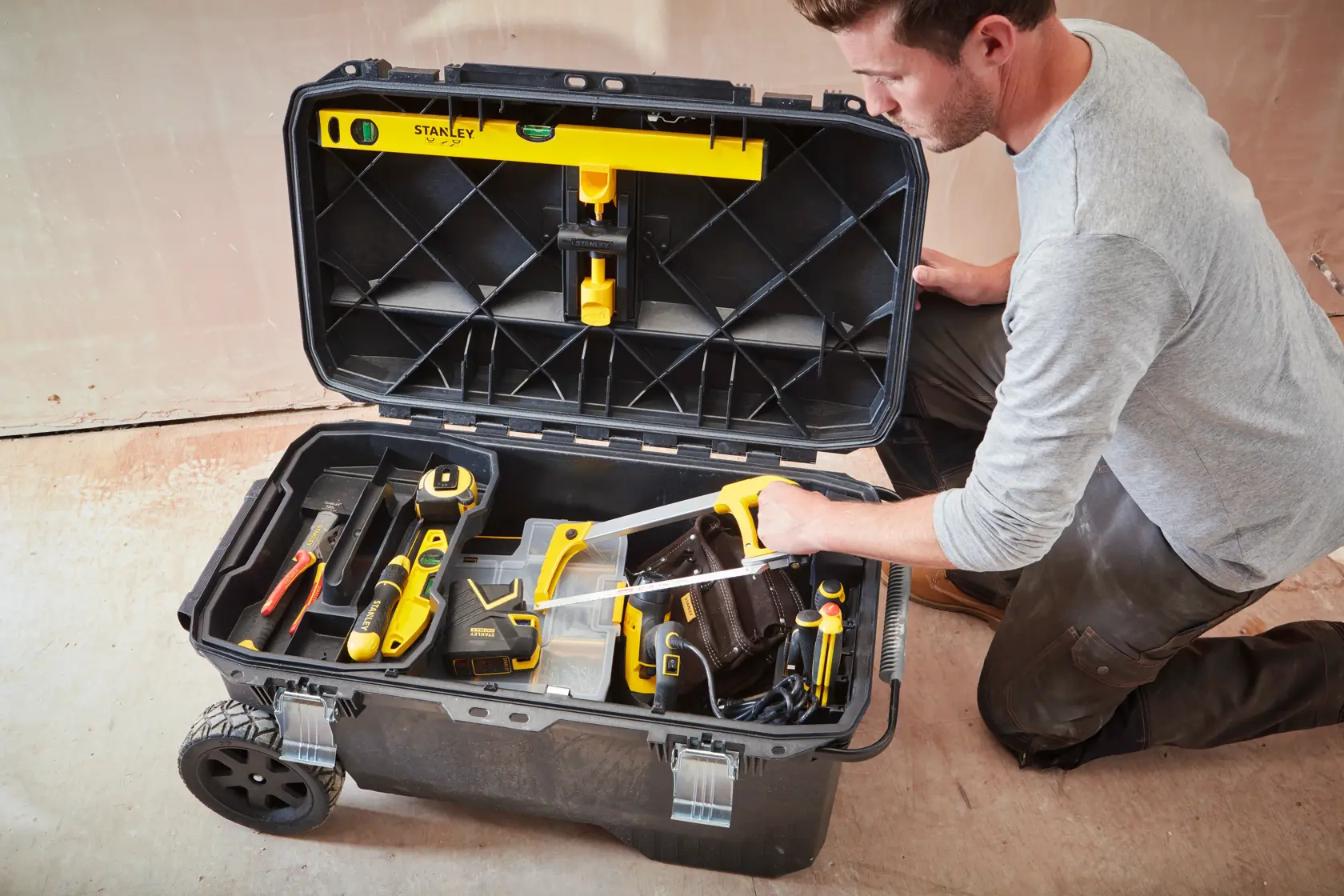 STANLEY 1-94-850 large wheeled tool box open, filled with assorted tools and accessories, photographed top-down.