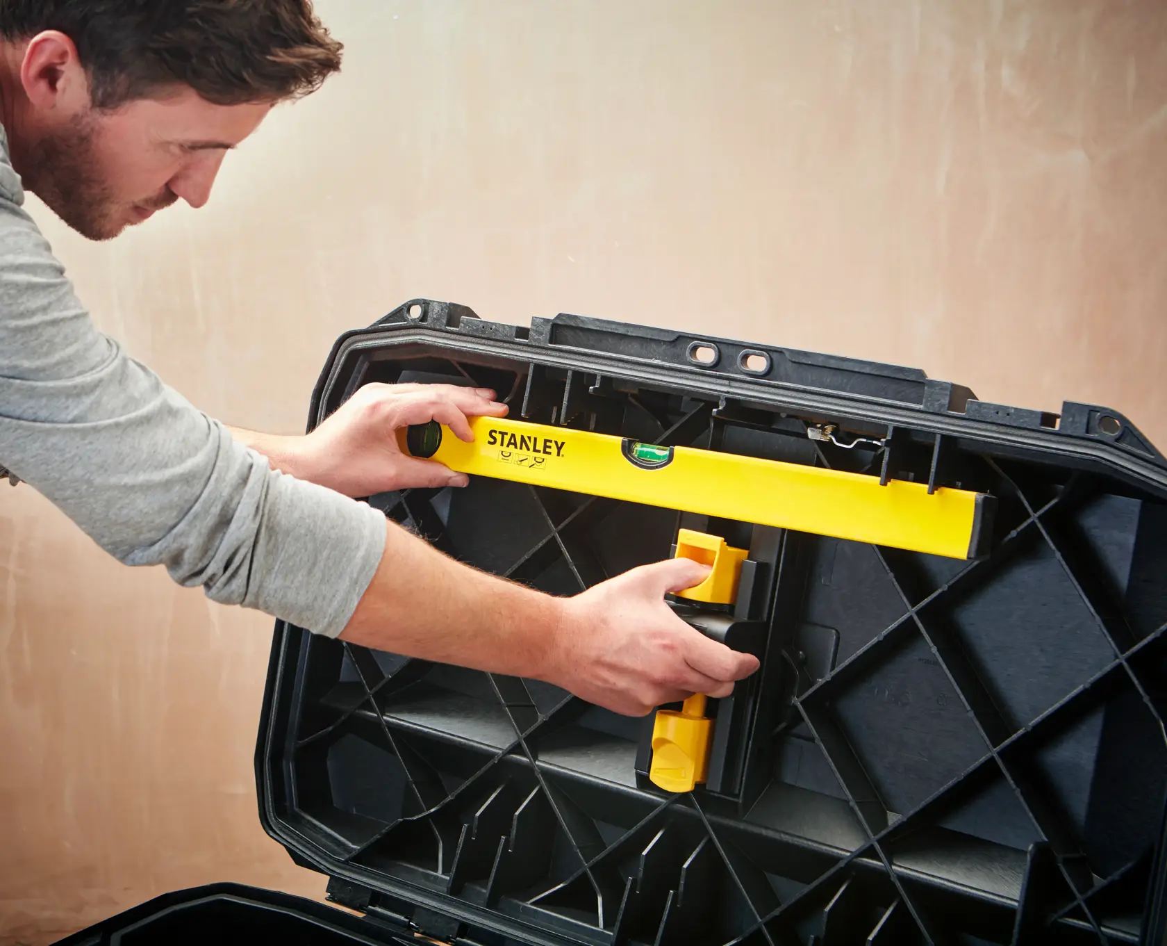 STANLEY 1-94-850 level tool being placed in a black hard case by a person, product photography.
