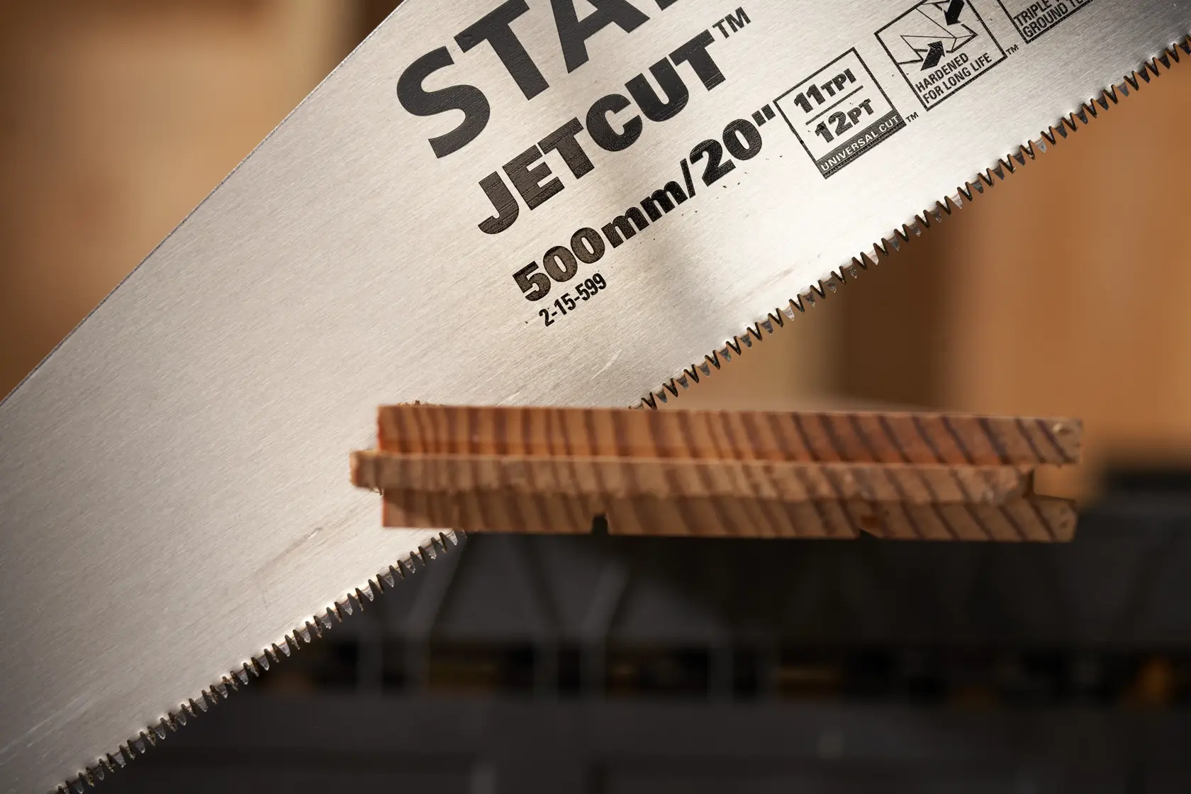 STANLEY 2-15-599 hand saw JetCut blade close-up cutting wood, photography side angle.