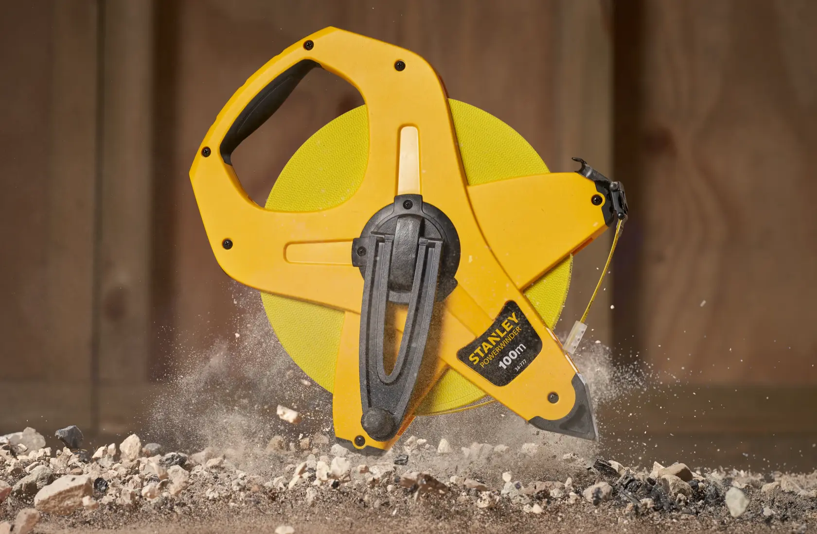 STANLEY 2-34-777 yellow open reel measuring tape on construction site, close-up view.