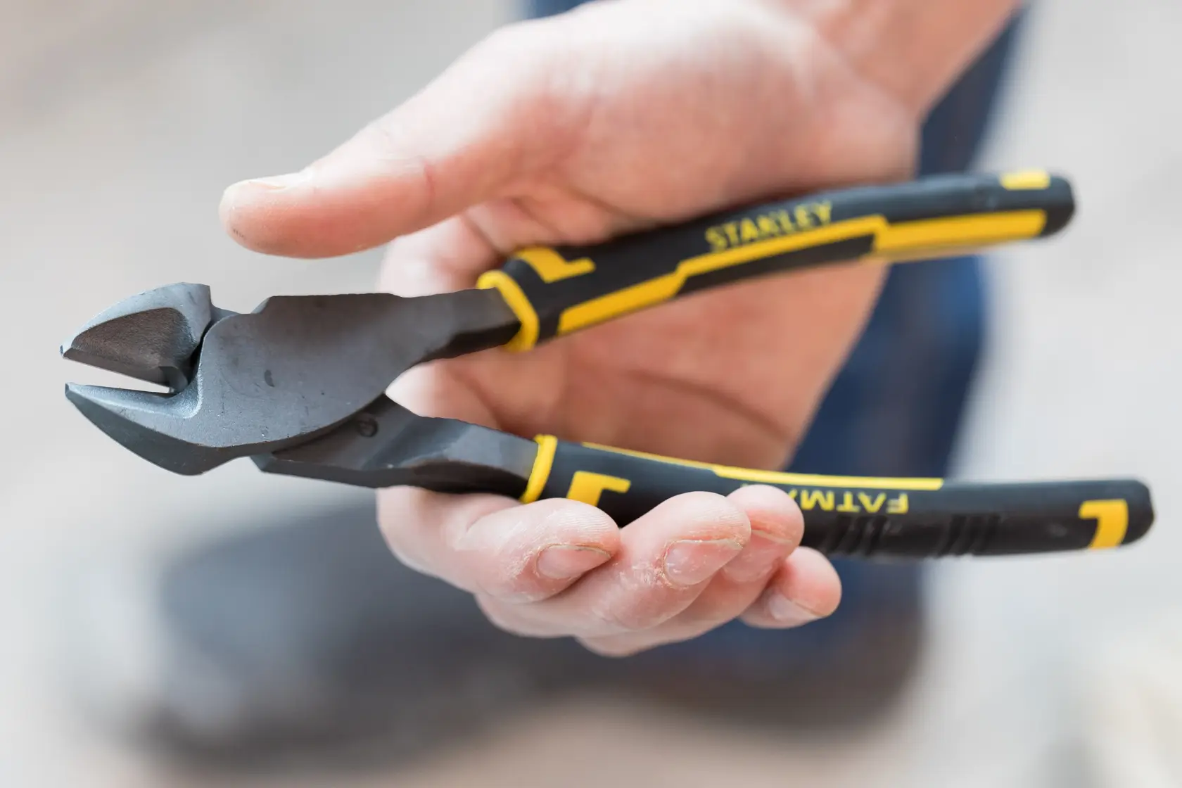 STANLEY 89-861 diagonal cutting pliers with black and yellow handles held in a hand, close-up view.