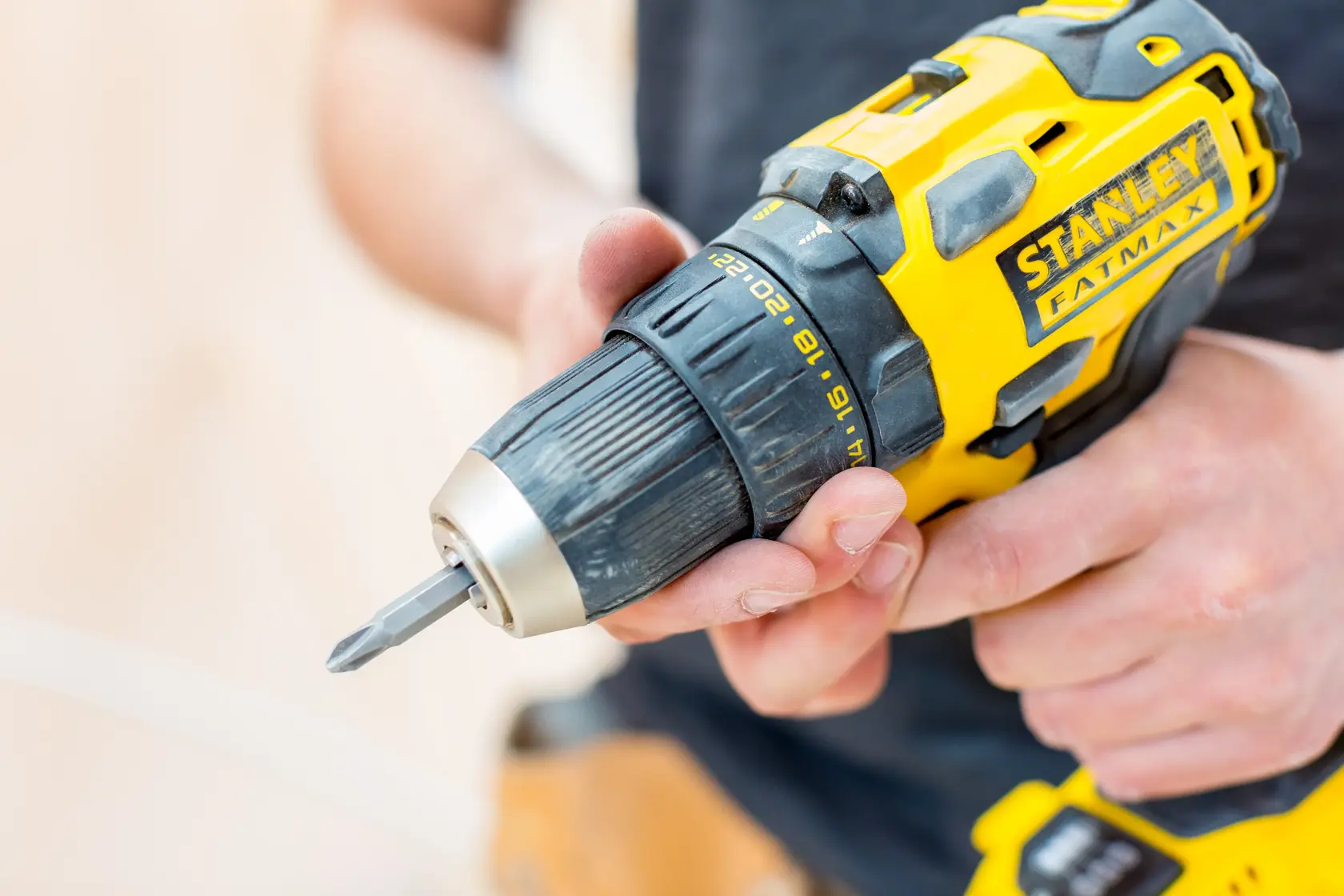 STANLEY FMC607D2T cordless drill in use, close-up photo showing yellow and black tool body.