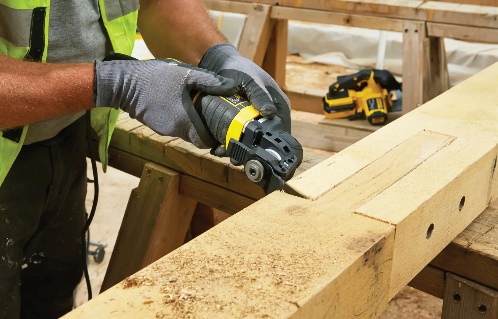 STANLEY FME650K multi-tool used to cut wood on workbench in workshop, close-up of tool in action.