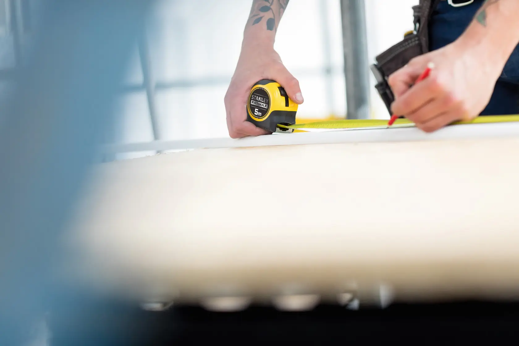 Photo of STANLEY FMHT36148-3 tape measure in use for marking measurements on a wooden surface.