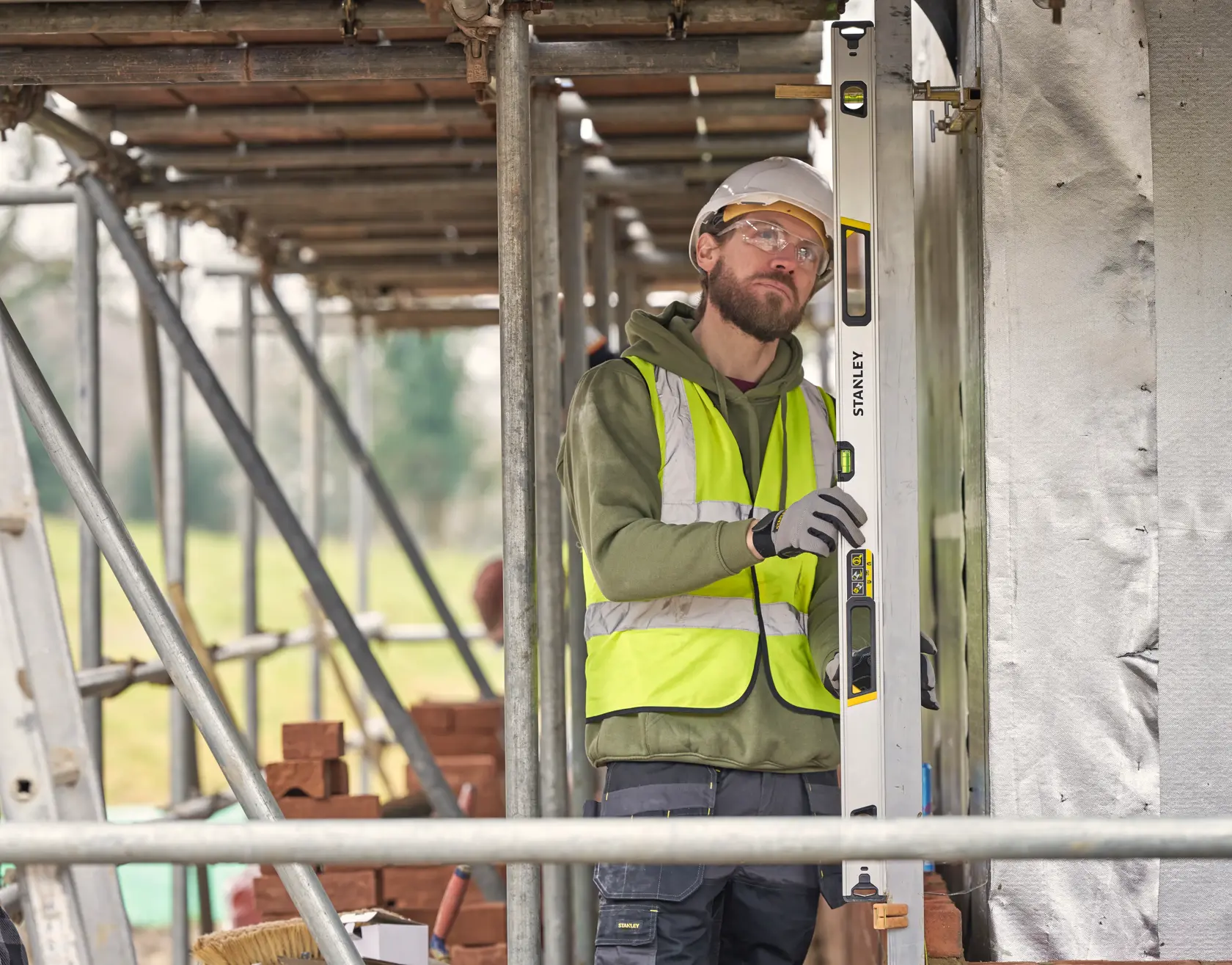 STANLEY FMHT43676-1 spirit level used vertically by construction worker on site.