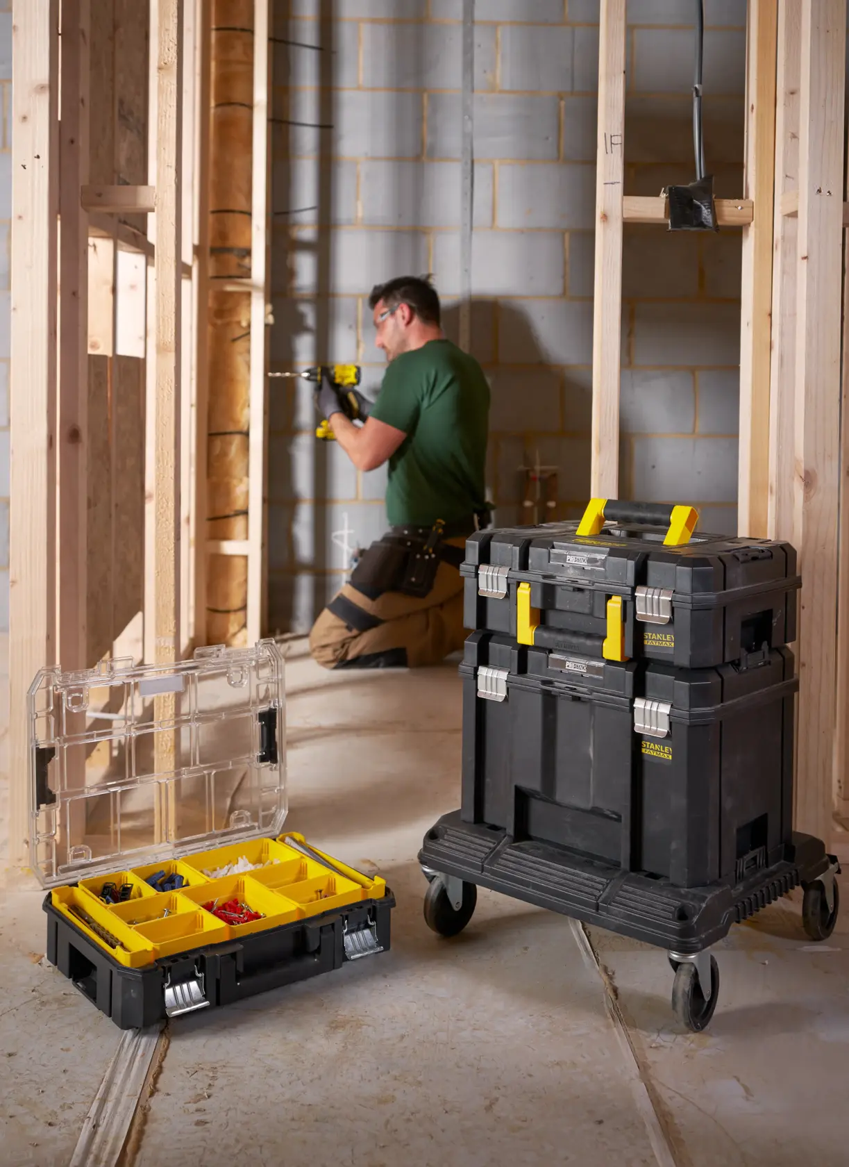 STANLEY FMST1-71971 rolling toolbox stack with yellow handles used at a construction site, open organizer with compartments.