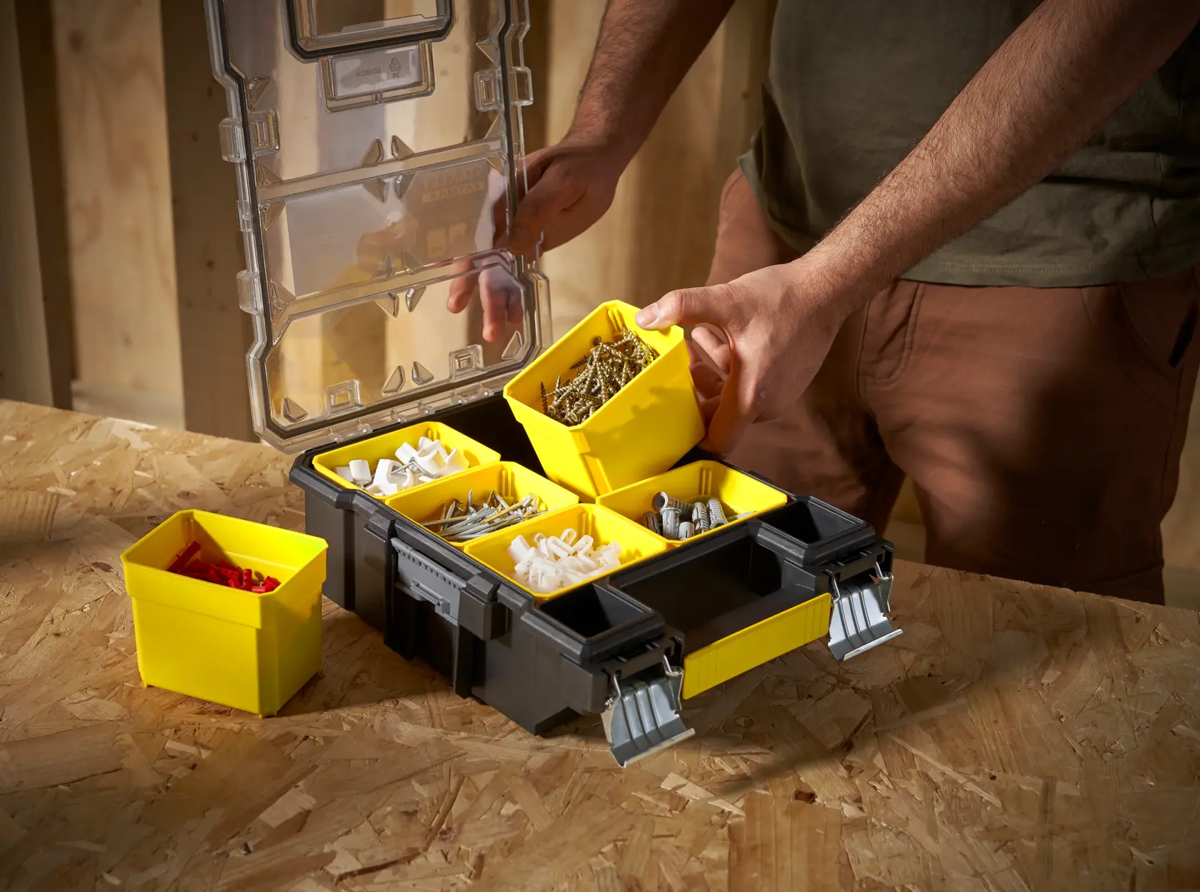 STANLEY FMST1-72378 organiser box with yellow removable bins, filled with assorted hardware, photo at tabletop angle.