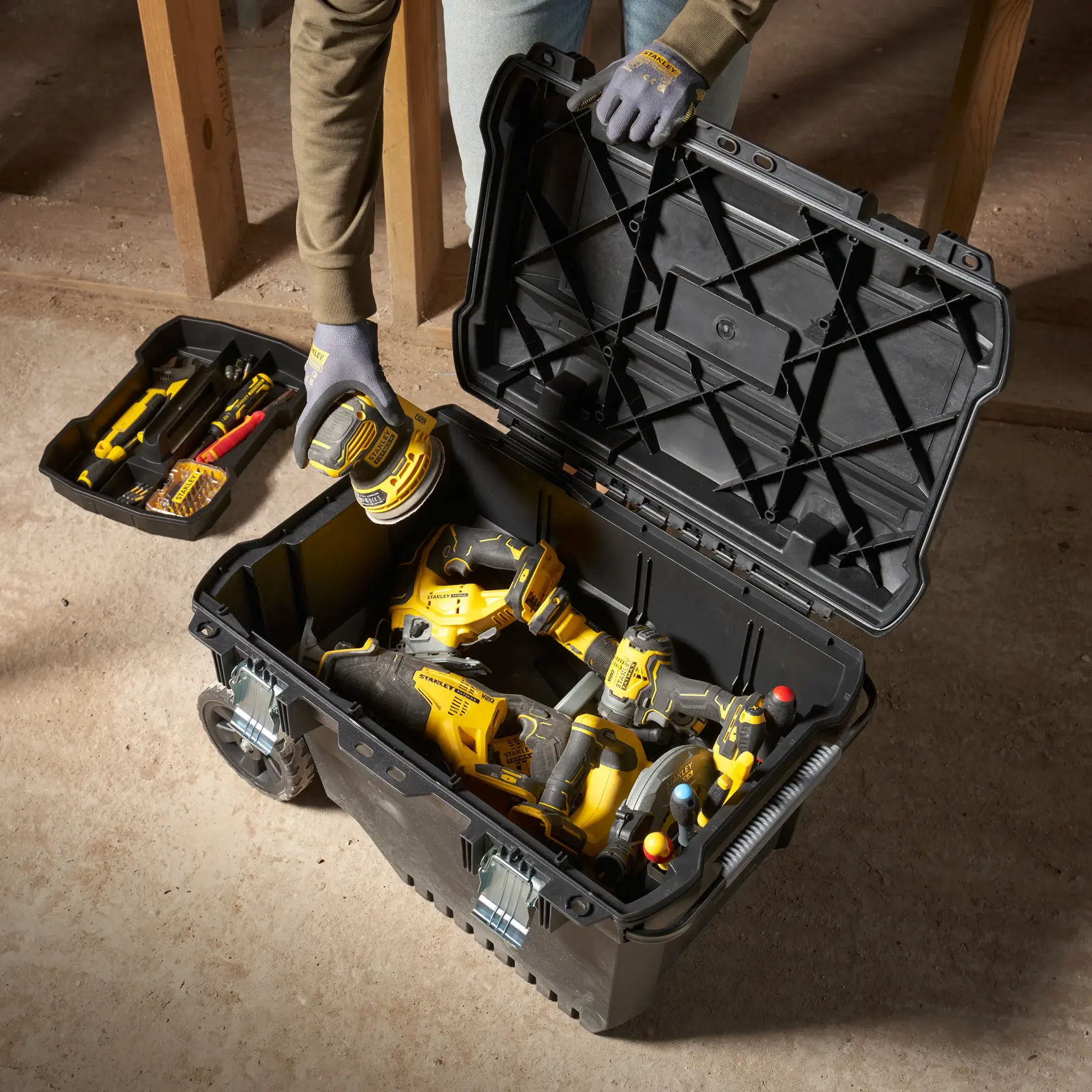STANLEY FMST1-73601 photography of black wheeled toolbox open, filled with yellow power tools, top view.