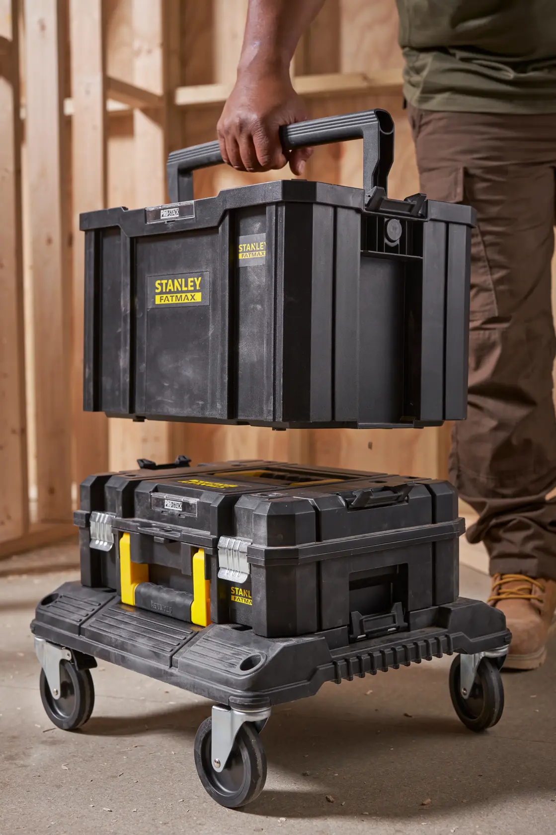 STANLEY FMST1-75794 stackable black toolboxes on wheeled trolley, photo shows handle grip and workshop setting.