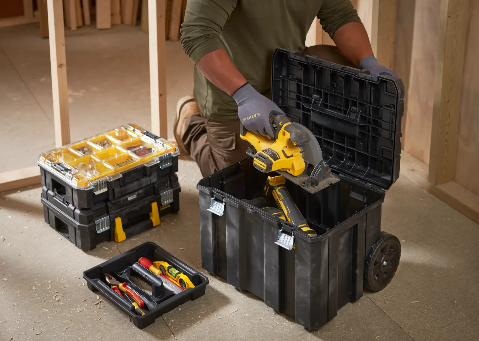 STANLEY FMST1-80101 stackable toolboxes with yellow compartments and wheeled base in jobsite setting.