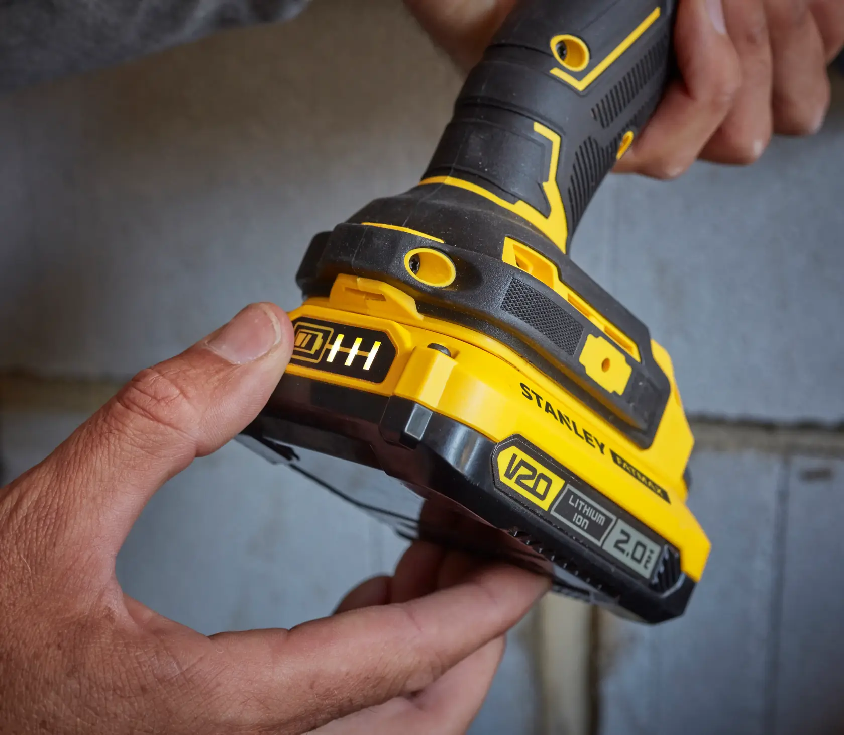 Photo of STANLEY SFMCB202 V20 Lithium Ion 2.0Ah battery attached to yellow and black power tool.