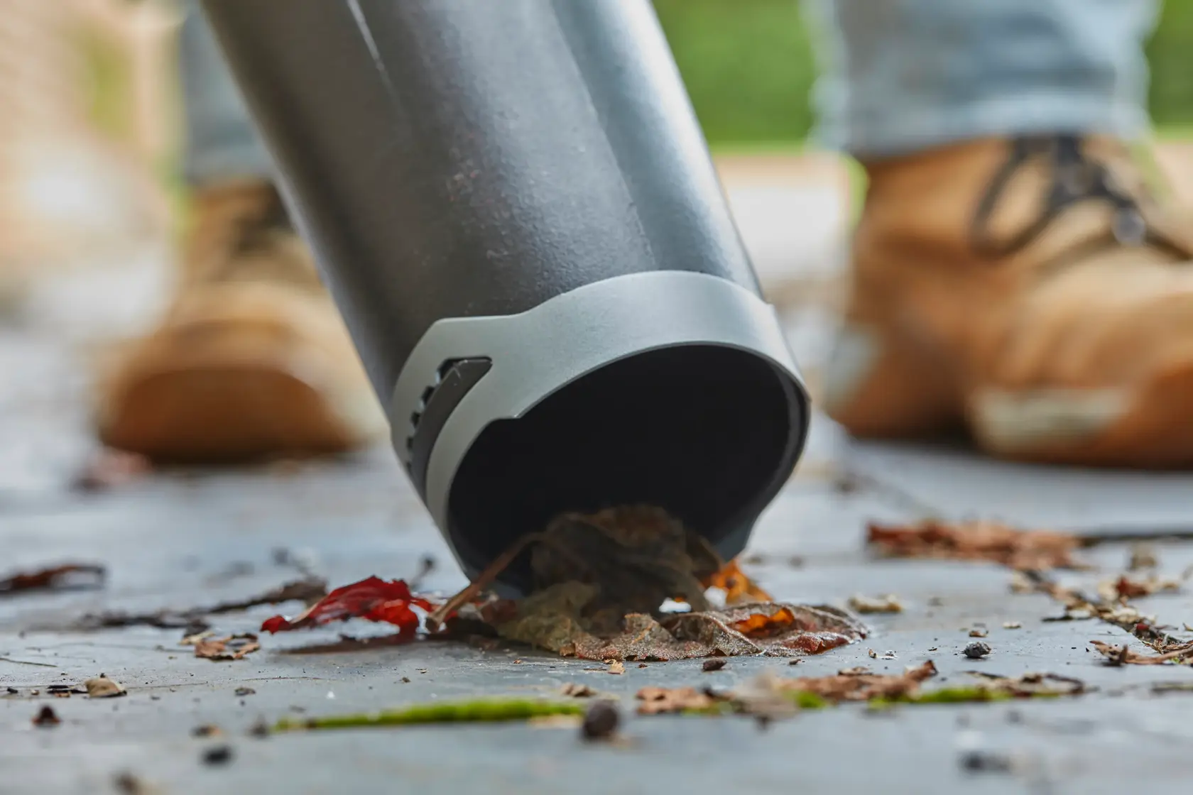 STANLEY SFMCBL7M1 blower nozzle close-up clearing leaves on pavement.