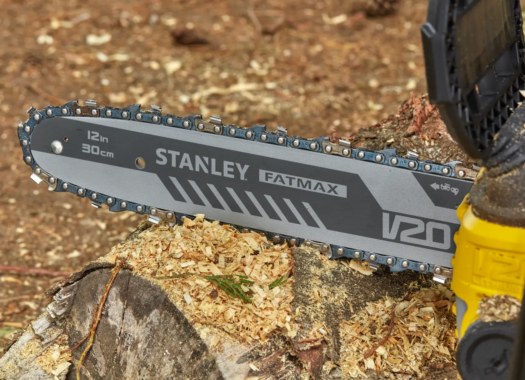 Photo of STANLEY SFMCCS630B chainsaw blade on tree stump, FATMAX V20, 12in/30cm bar, close-up view.