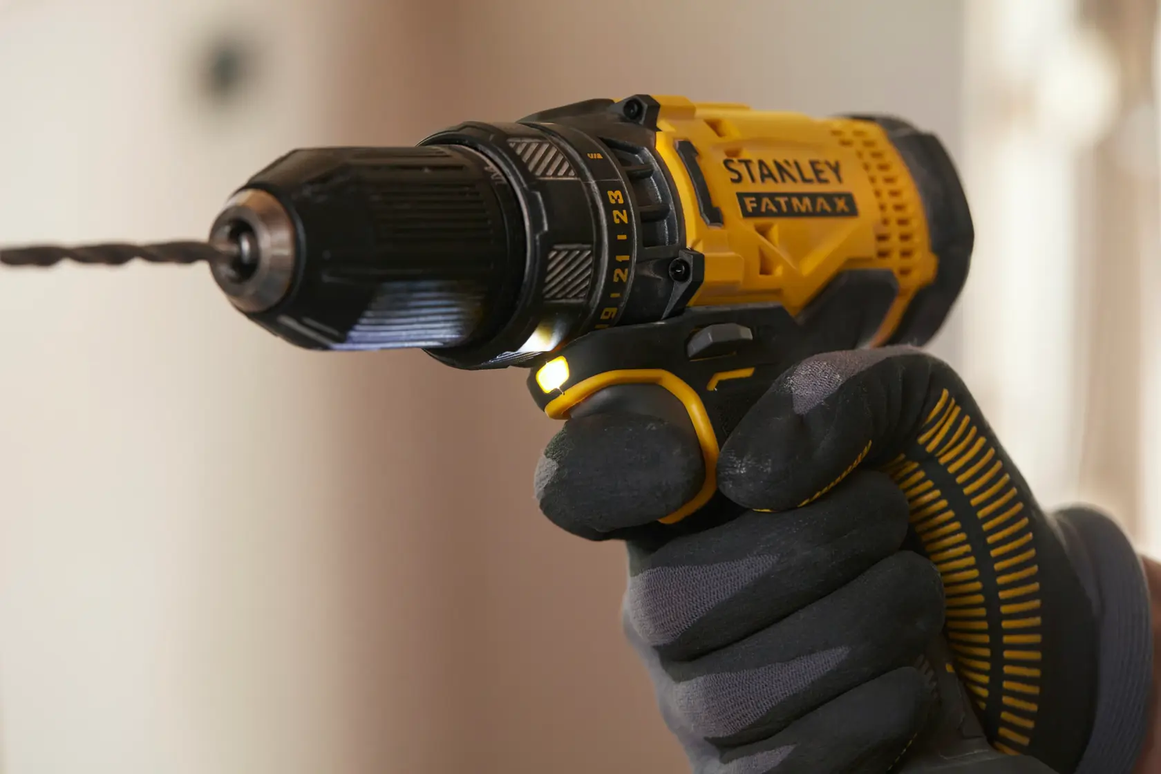 STANLEY SFMCD700D2S cordless drill with drill bit in use, yellow and black, close-up side angle.