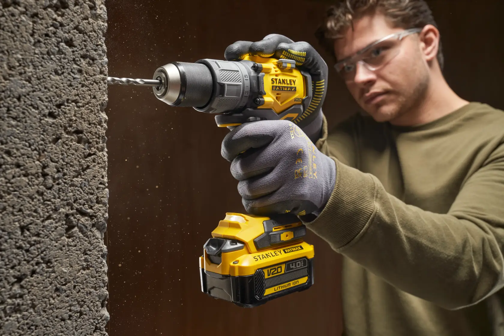 Photo of STANLEY SFMCD726B cordless drill in use, drilling into concrete.