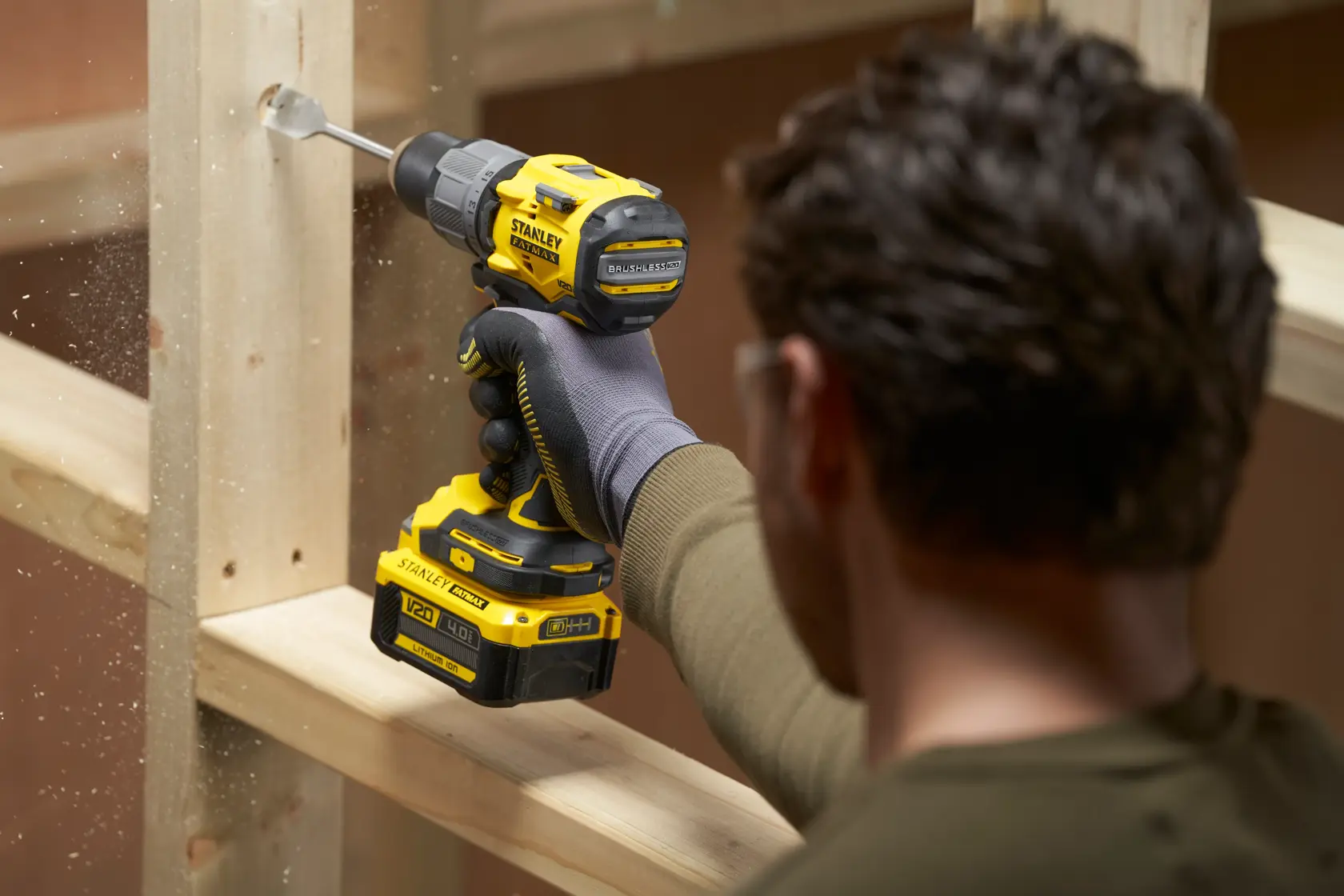 Photo of a person using a STANLEY SFMCD726B cordless drill to bore a hole in a wooden frame.