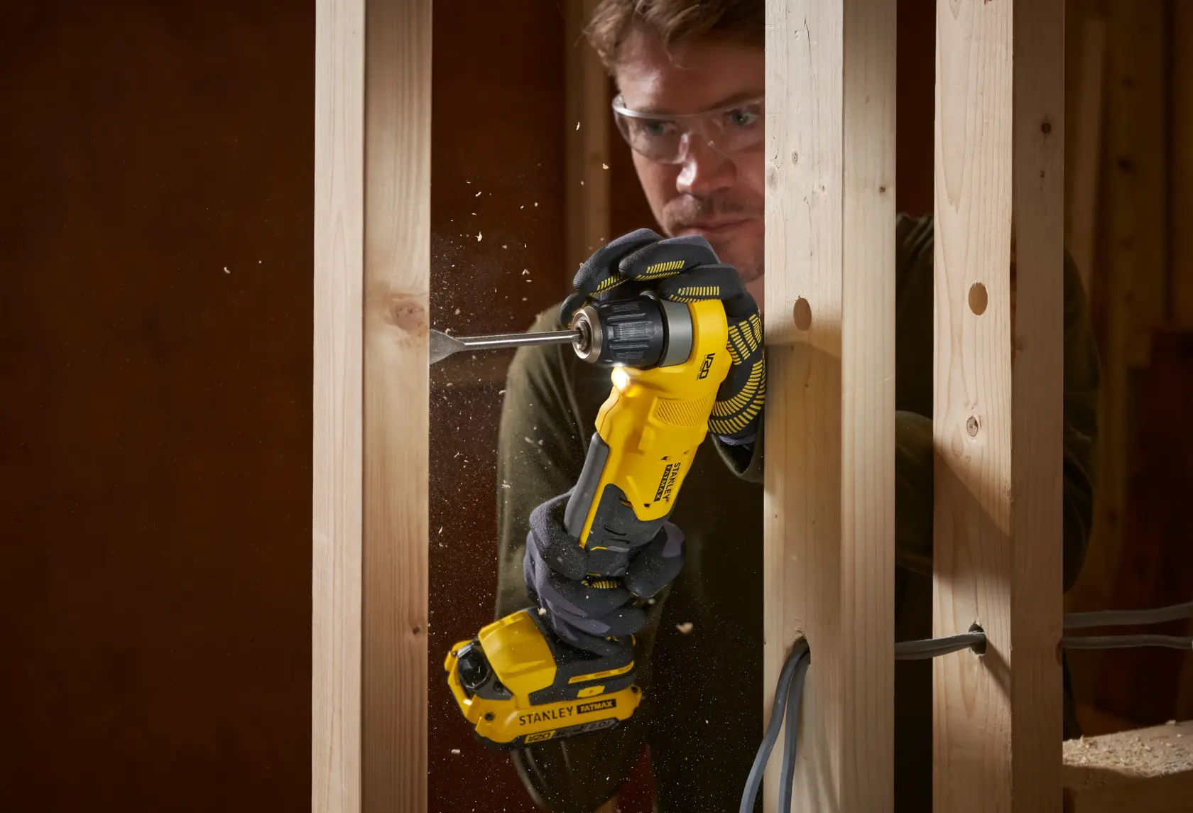 Stanley SFMCD750B cordless drill photo in use drilling into wooden frame.