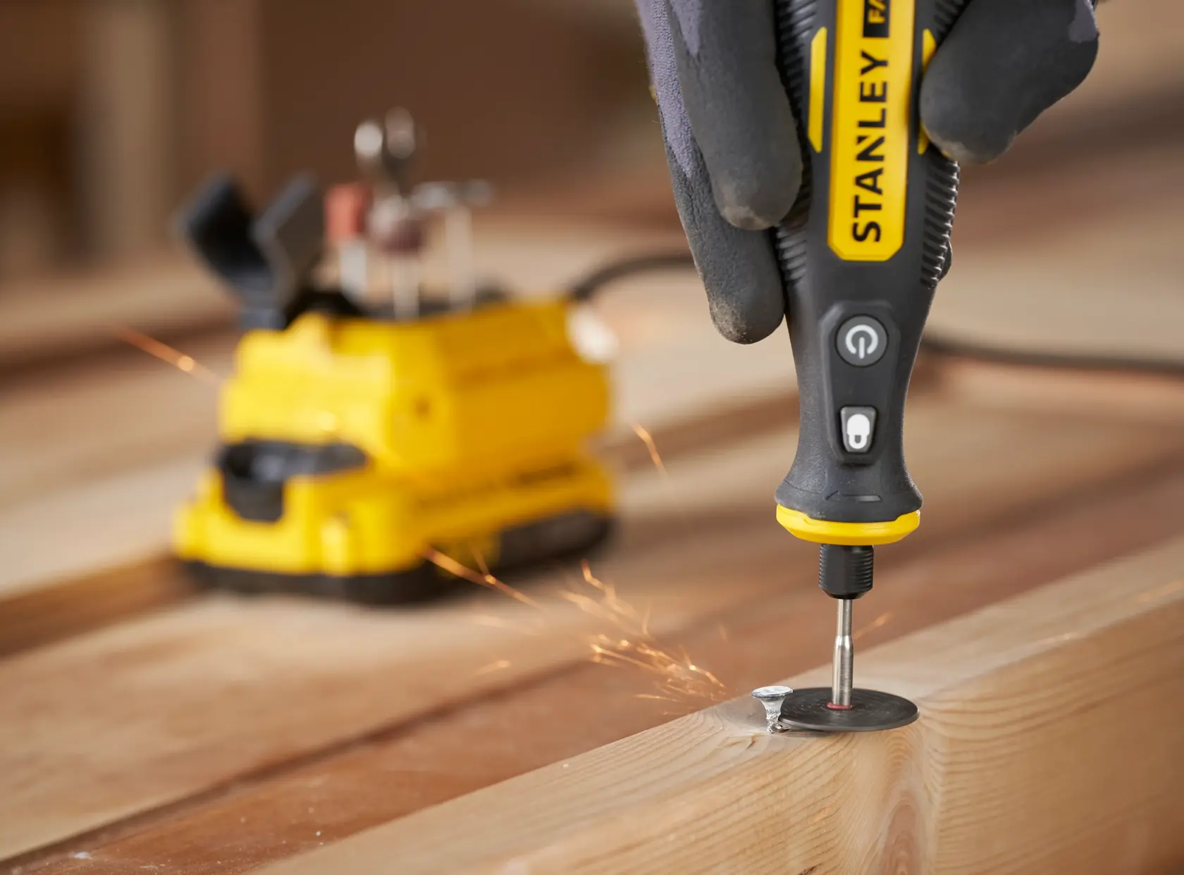 STANLEY SFMCE030B rotary tool used on wood, with sparks flying, close-up photography angle.