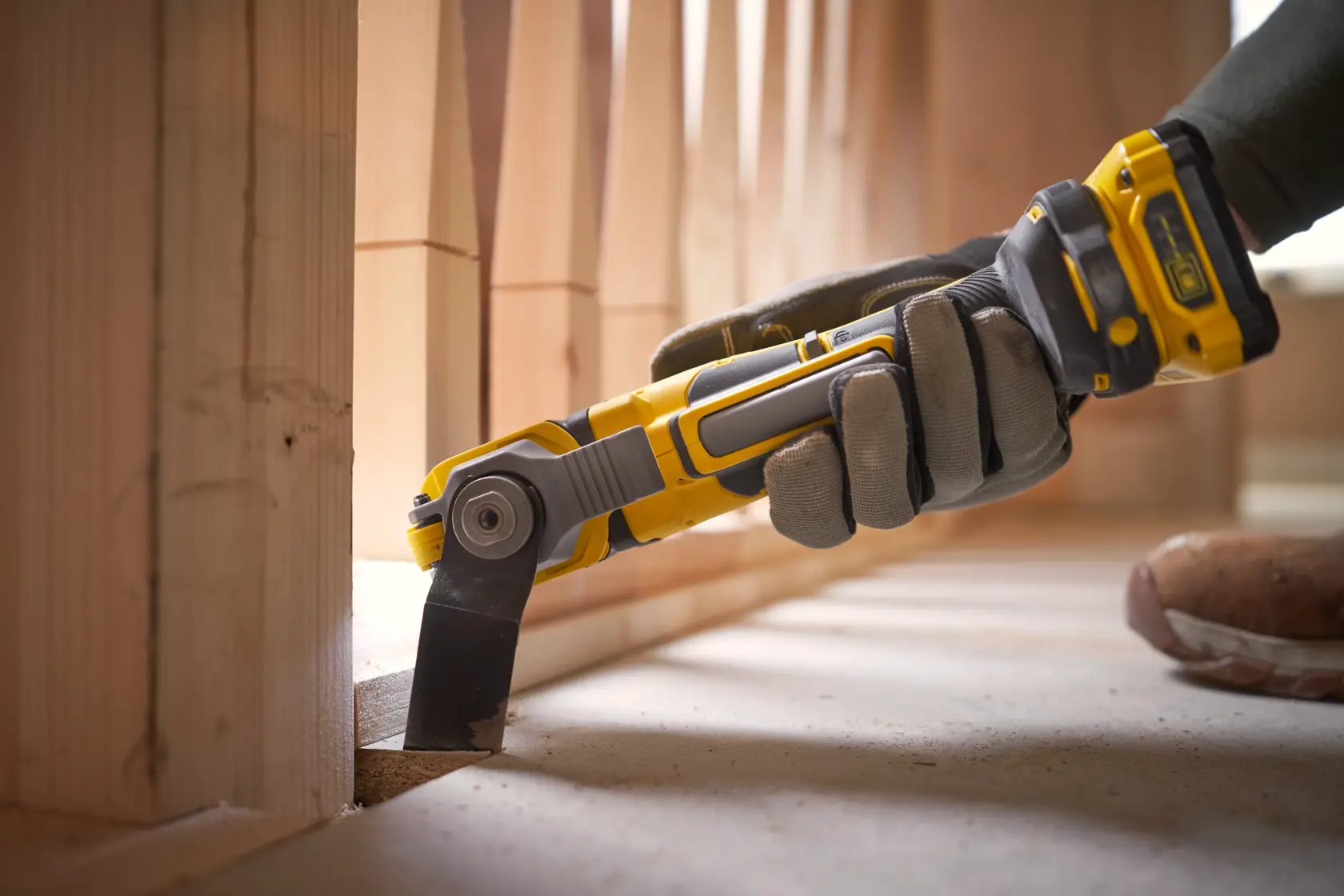 STANLEY SFMCE510B oscillating tool in use, yellow and black design, cutting wood near flooring.