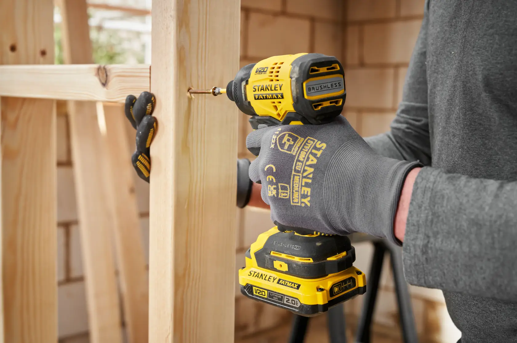 STANLEY SFMCF811B-XJ V20 brushless impact driver in use driving screw into wooden frame.