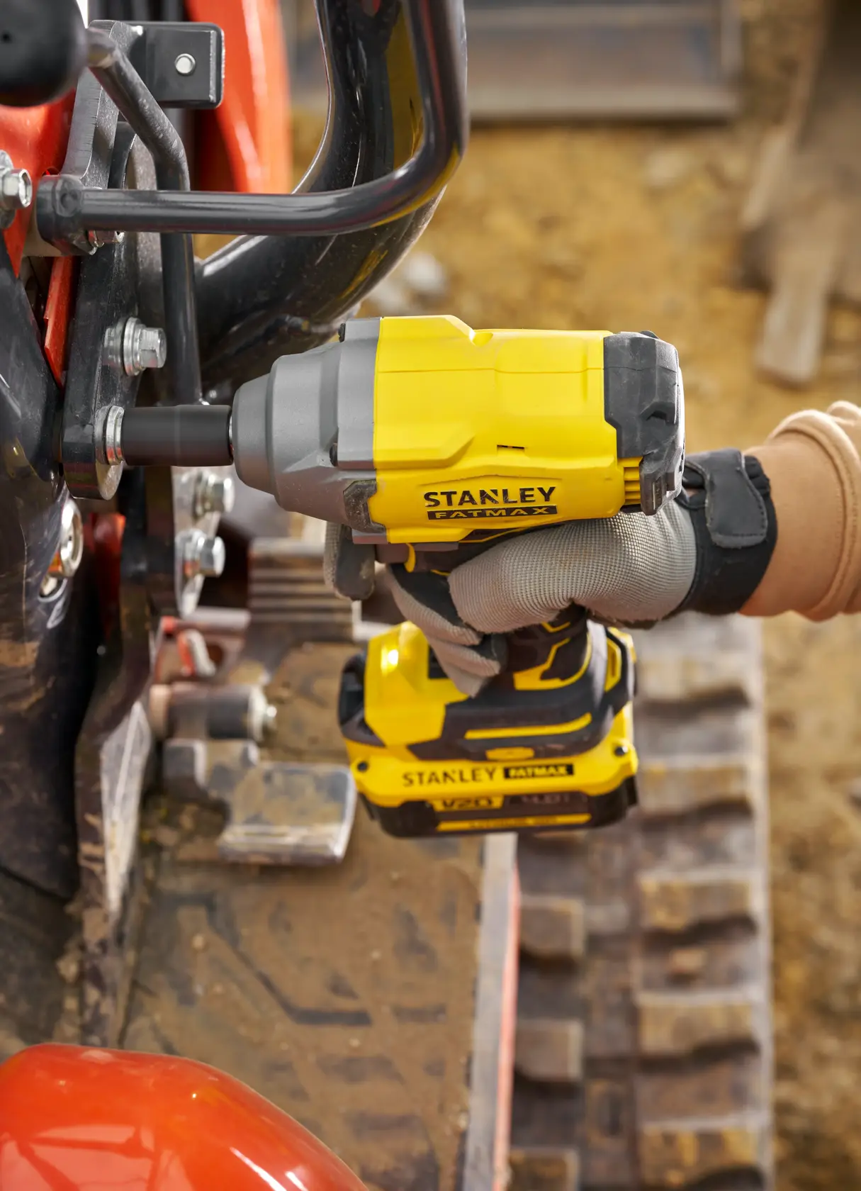 STANLEY SFMCF920B impact wrench in use, side angle, yellow and black, tightening bolt on machinery.