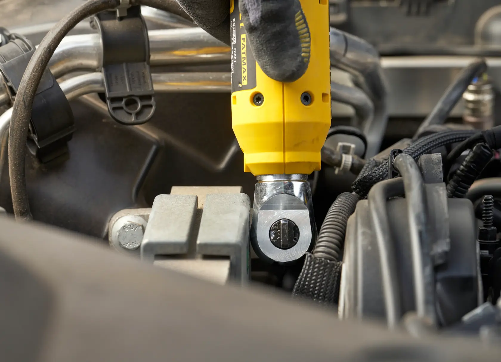 STANLEY SFMCF930B impact wrench used on an engine component, close-up photography.
