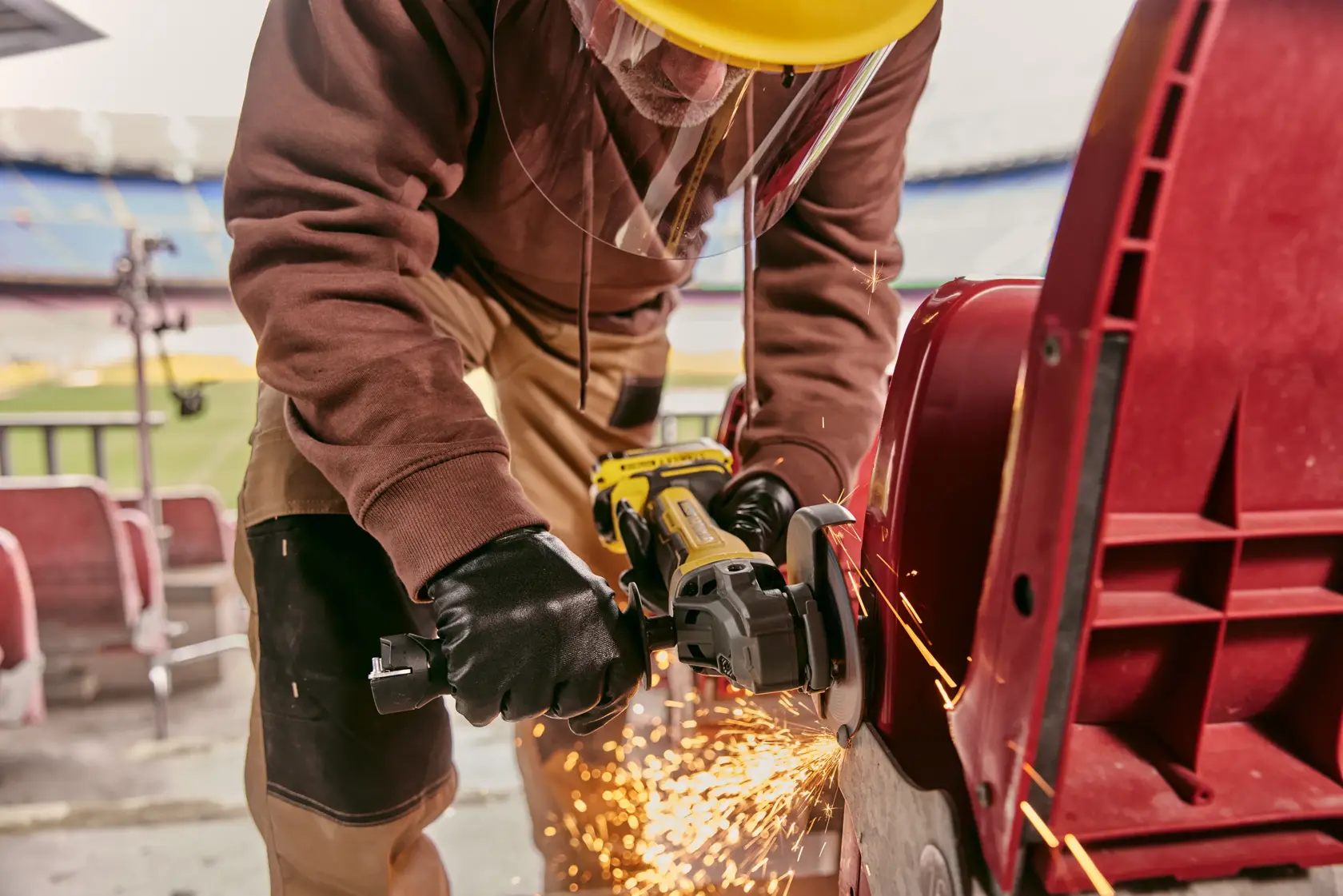 STANLEY SFMCG700M2K grinder in use, worker cutting metal with sparks, close-up shot, photography category.