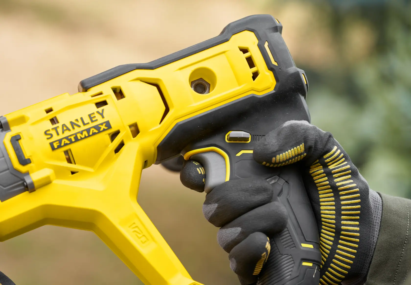 Photo of STANLEY SFMCGA75B FATMAX cordless tool handle held by gloved hand, yellow and black design.