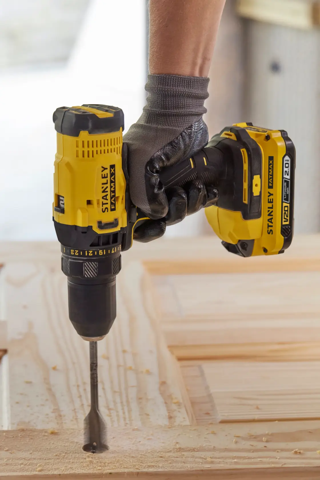 STANLEY SFMCK470D2 cordless drill in use, drilling into wood, close-up side angle.