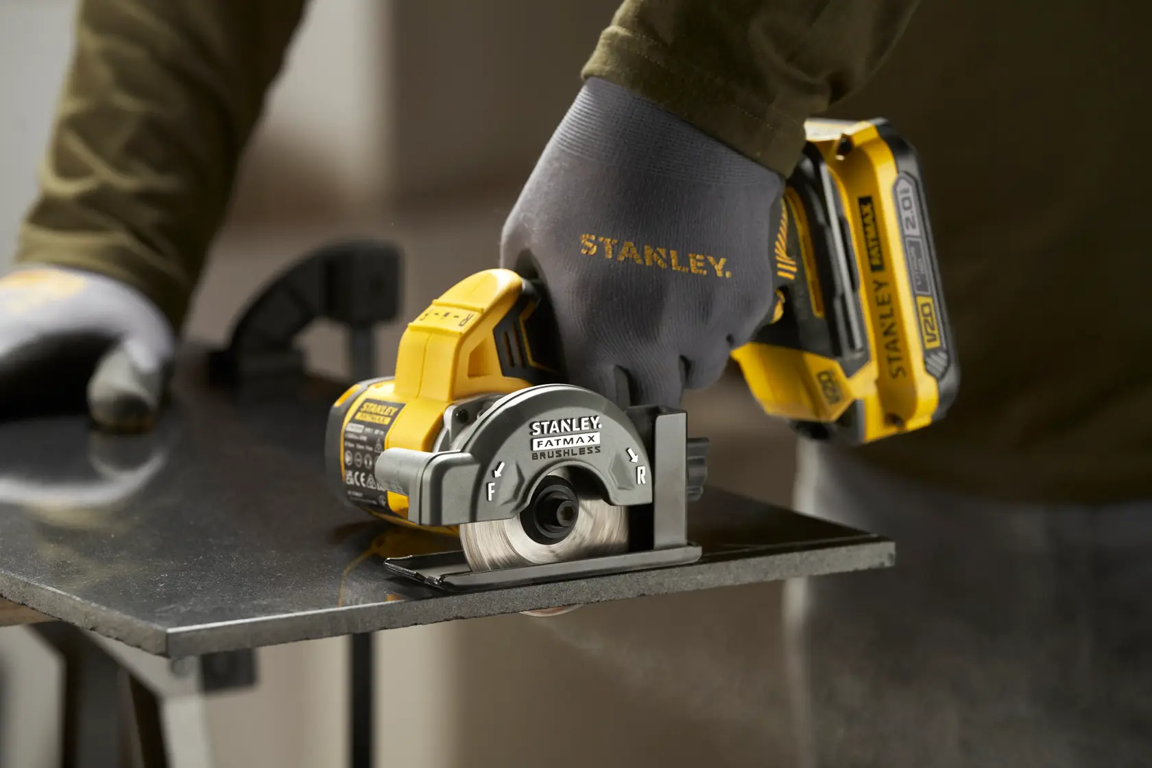 Photo of STANLEY SFMCM300B compact cordless circular saw cutting metal, worker wearing STANLEY gloves.