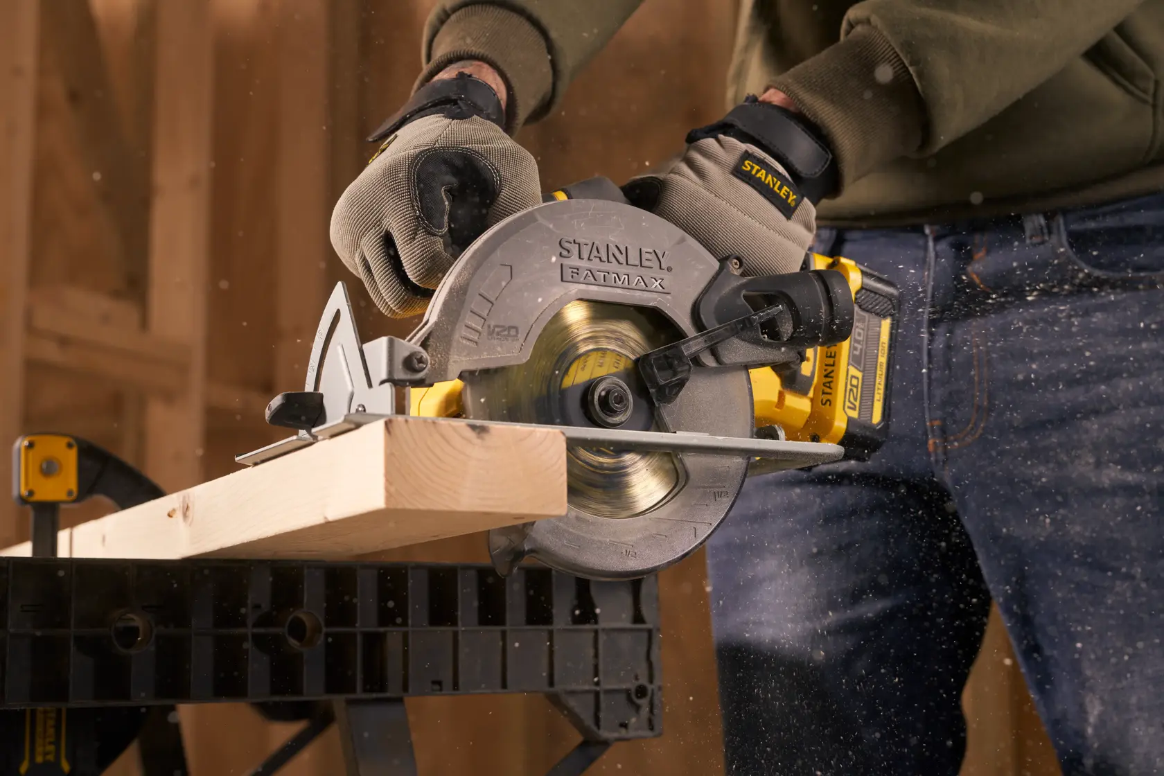 Stanley SFMCS500M1S circular saw cutting timber, close-up, with sawdust flying in workshop.