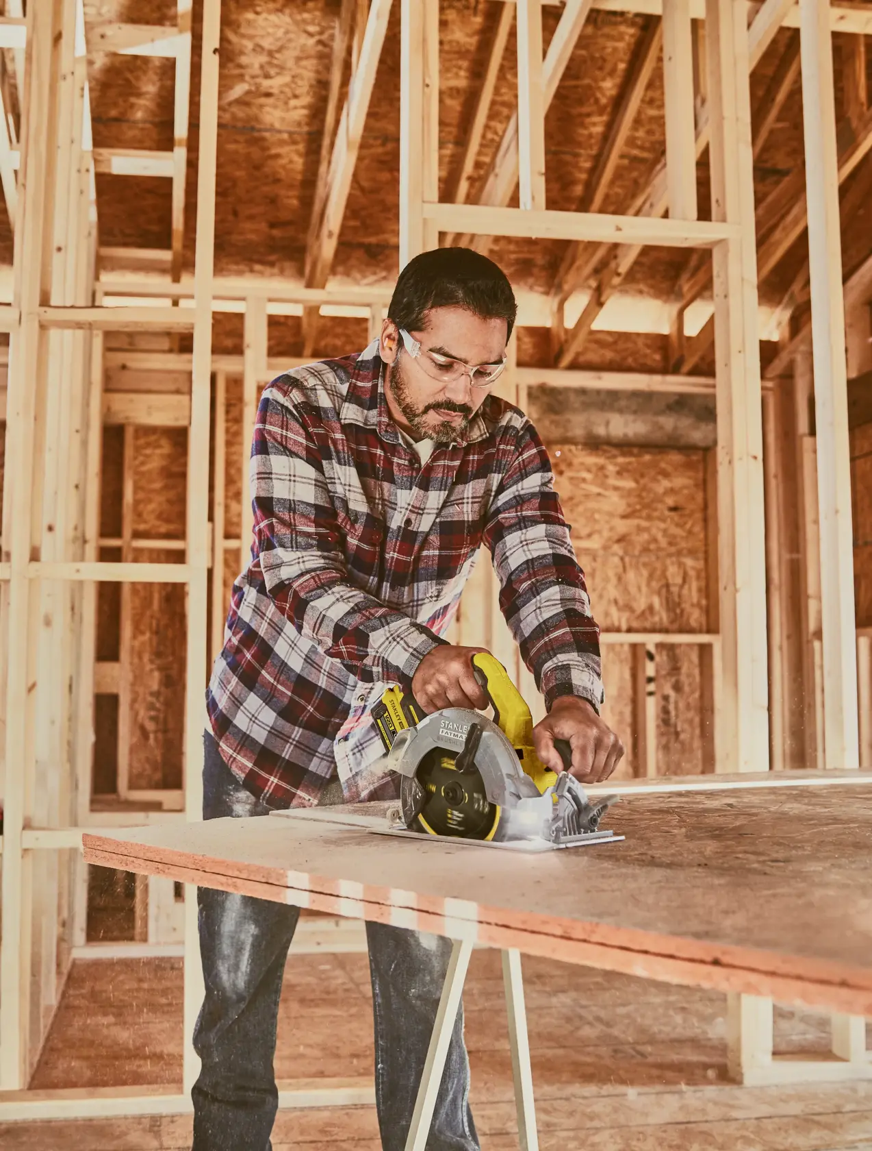 STANLEY SFMCS550B cordless circular saw cutting plywood in construction setting.