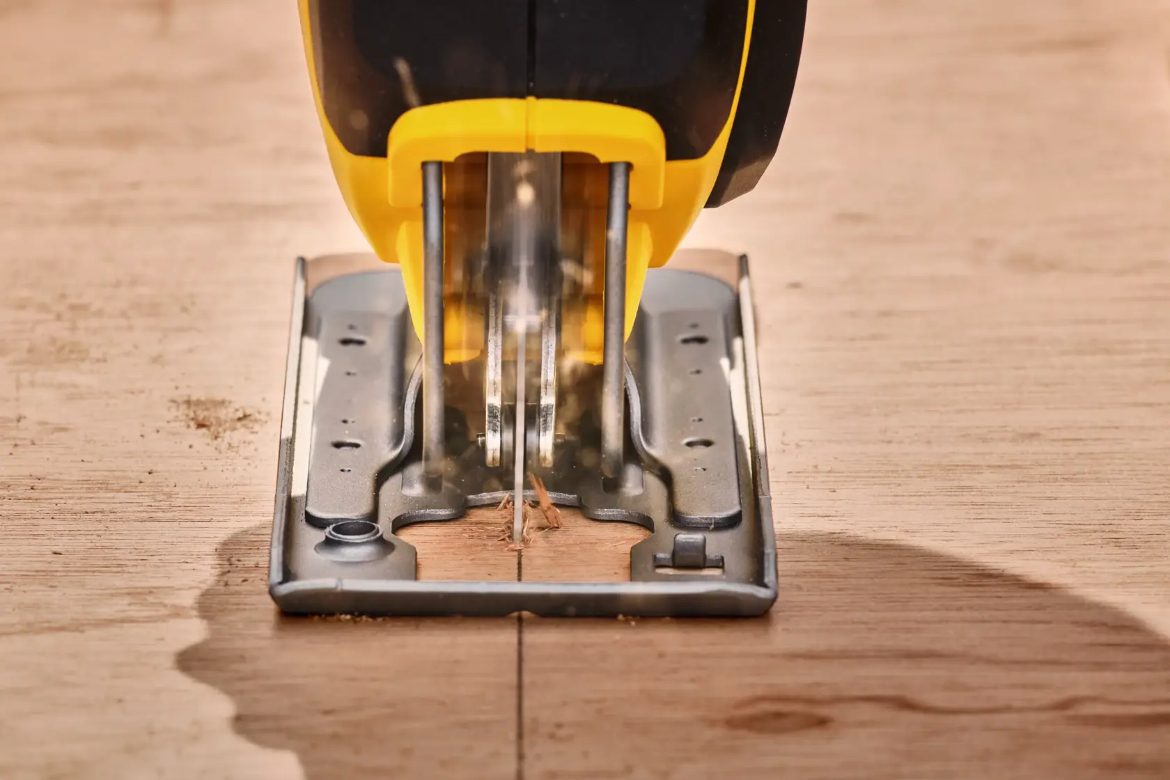STANLEY SFMCS600B jigsaw cutting wood, front angle, yellow and black body, close-up photo.