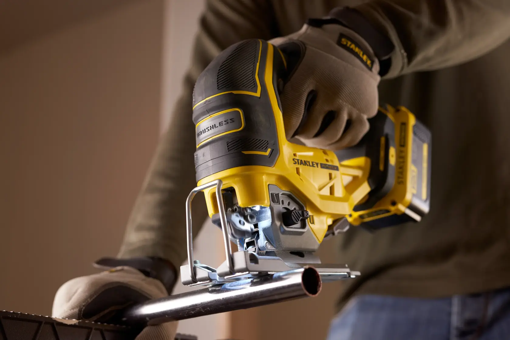 STANLEY SFMCS650B 18V FATMAX V20 brushless jigsaw cutting metal pipe, close-up photography.