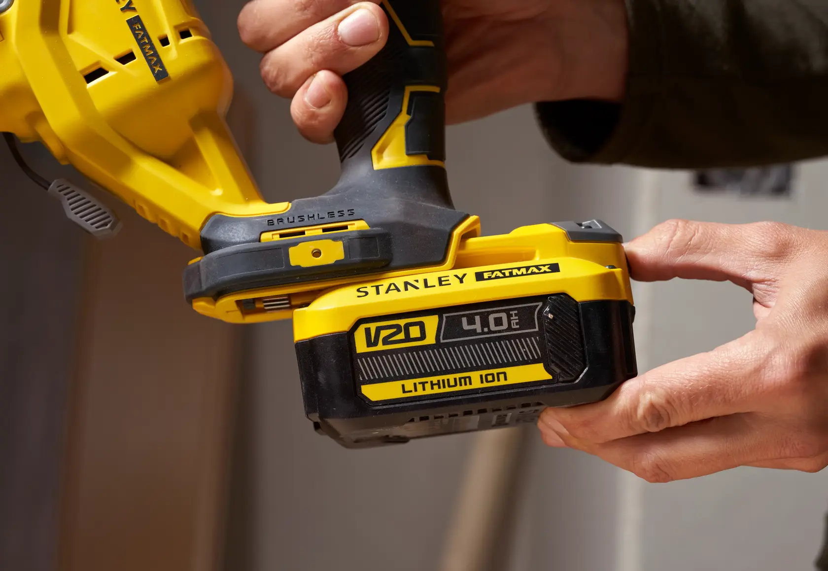Photo of STANLEY SFMCS650B 18V FATMAX V20 brushless jigsaw held in hand, showing V20 Lithium Ion battery close-up.