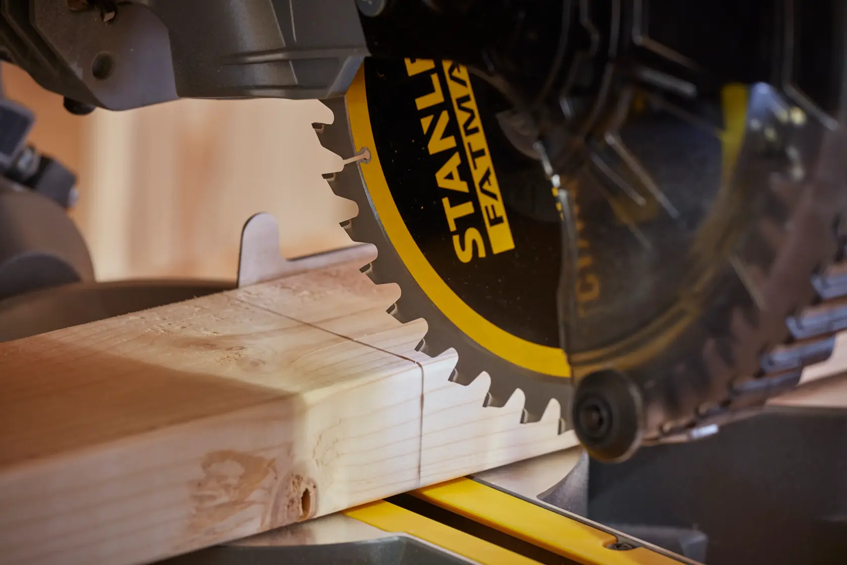 STANLEY SFMCS701B miter saw cutting wood, close-up photo of saw blade and timber.