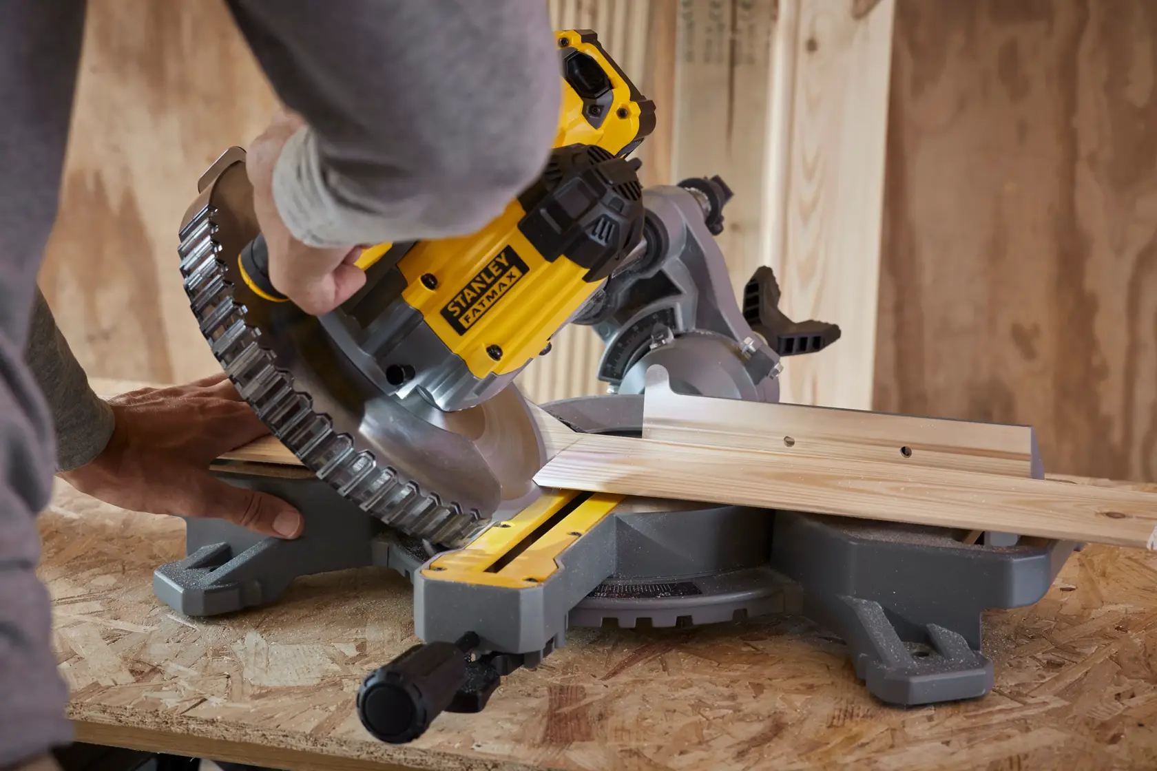 STANLEY SFMCS701M2 miter saw cutting wood, close-up angle in workshop setting.