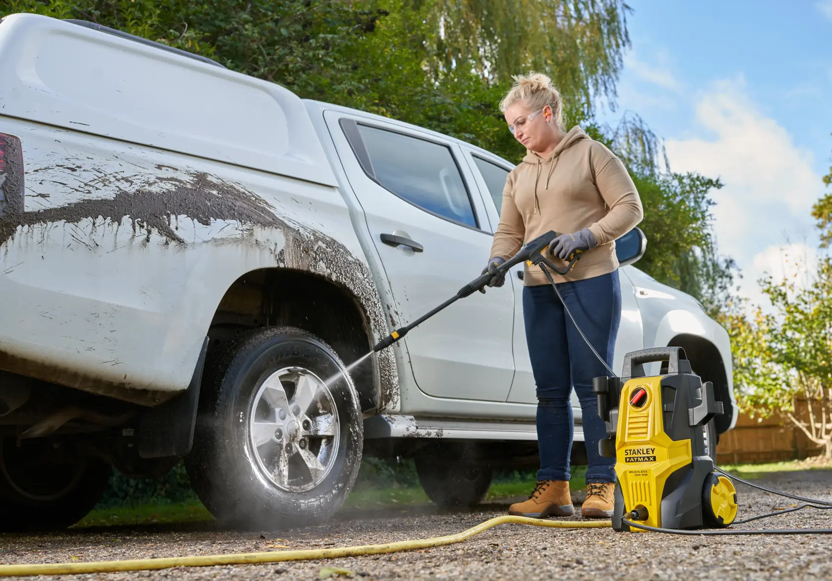 STANLEY SFMPW1740 pressure washer cleaning white truck outdoors, yellow and black unit visible in use.