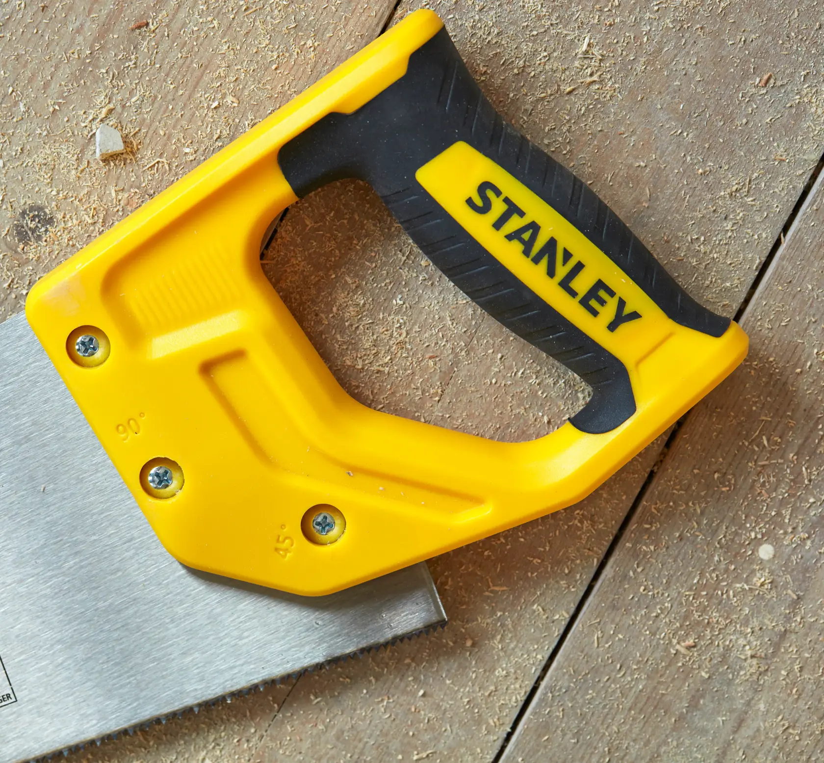 STANLEY STHT20372-1 saw with yellow and black handle, angled on wooden surface, close-up photography.