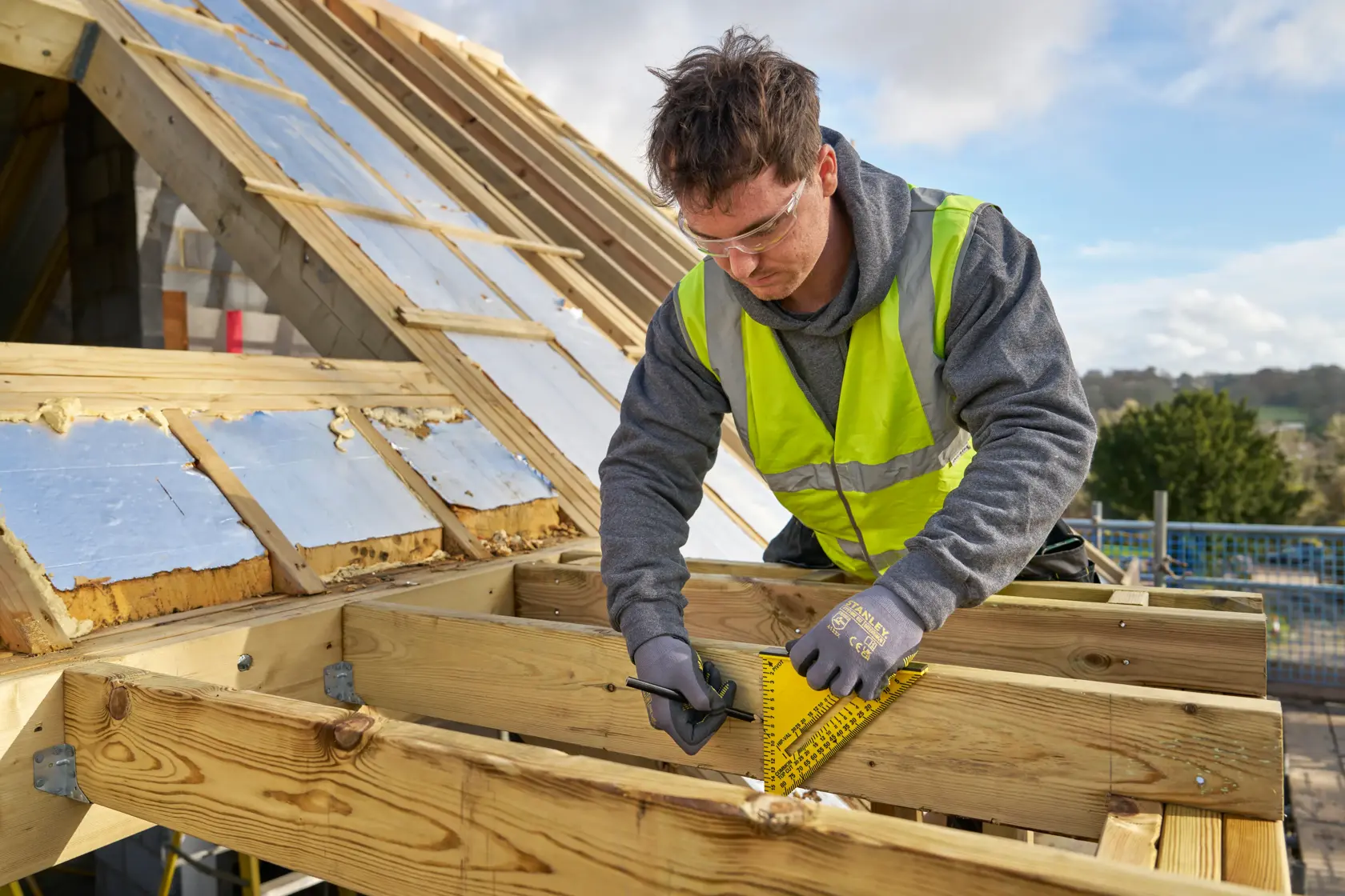 Photo of a worker using a STANLEY STHT46012-0 rafter square on timber at a construction site.