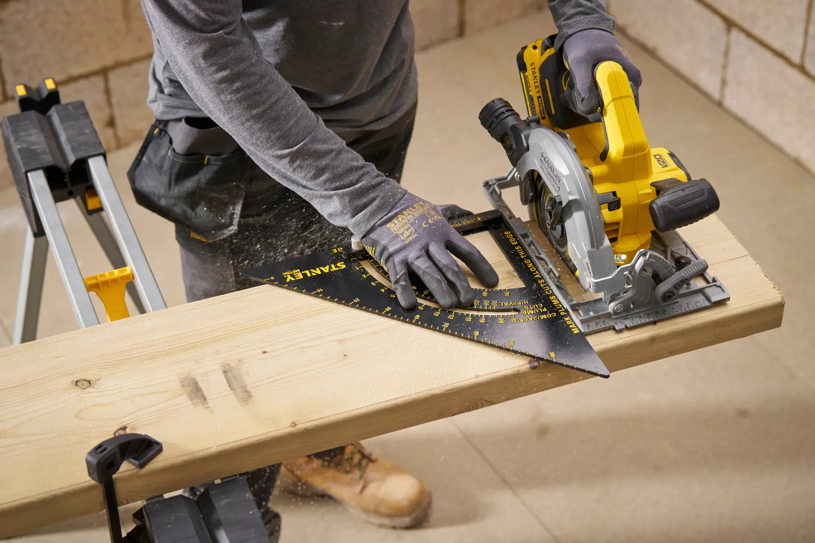 Photo of STANLEY STHT46054-0 square tool on wooden board, used by worker with circular saw in workshop.