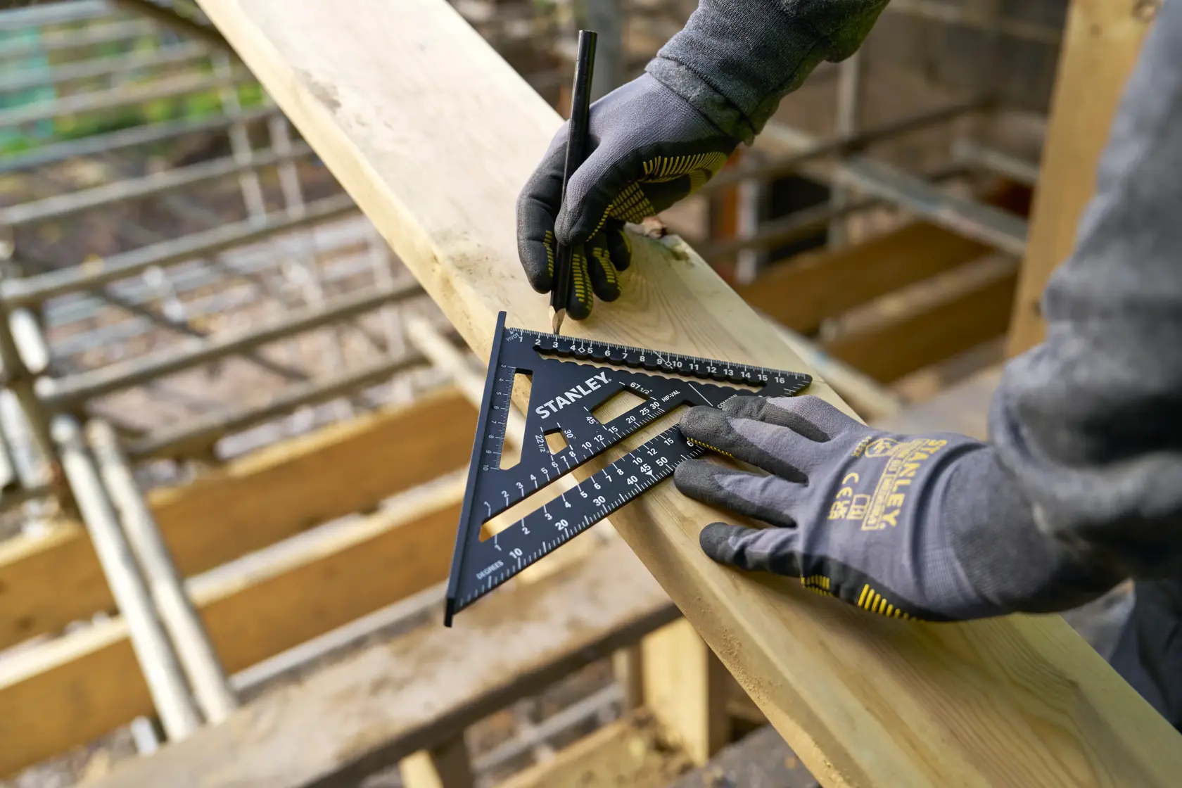 STANLEY STHT46101-0 carpenter's square for marking wood, gloved hands, outdoor construction.