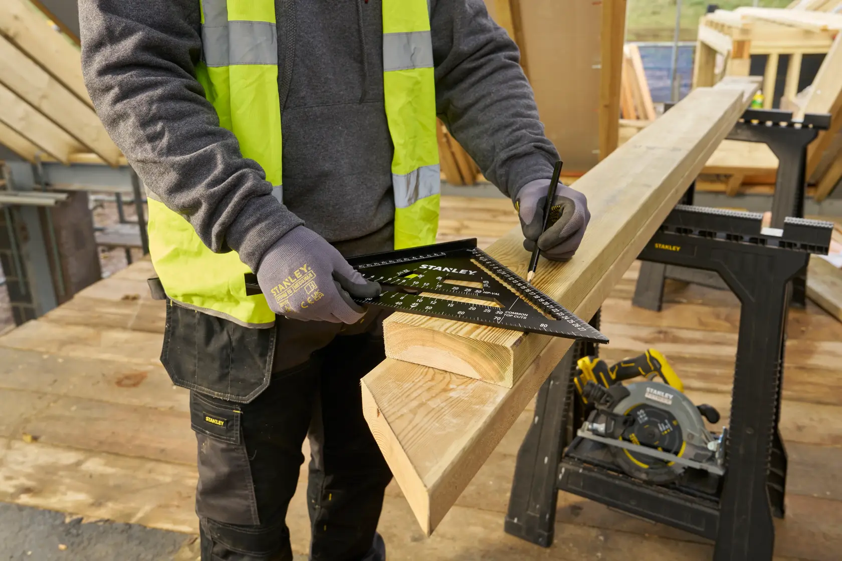 STANLEY STHT46102-0 rafter square in use marking wood, outdoor construction site, product demonstration.