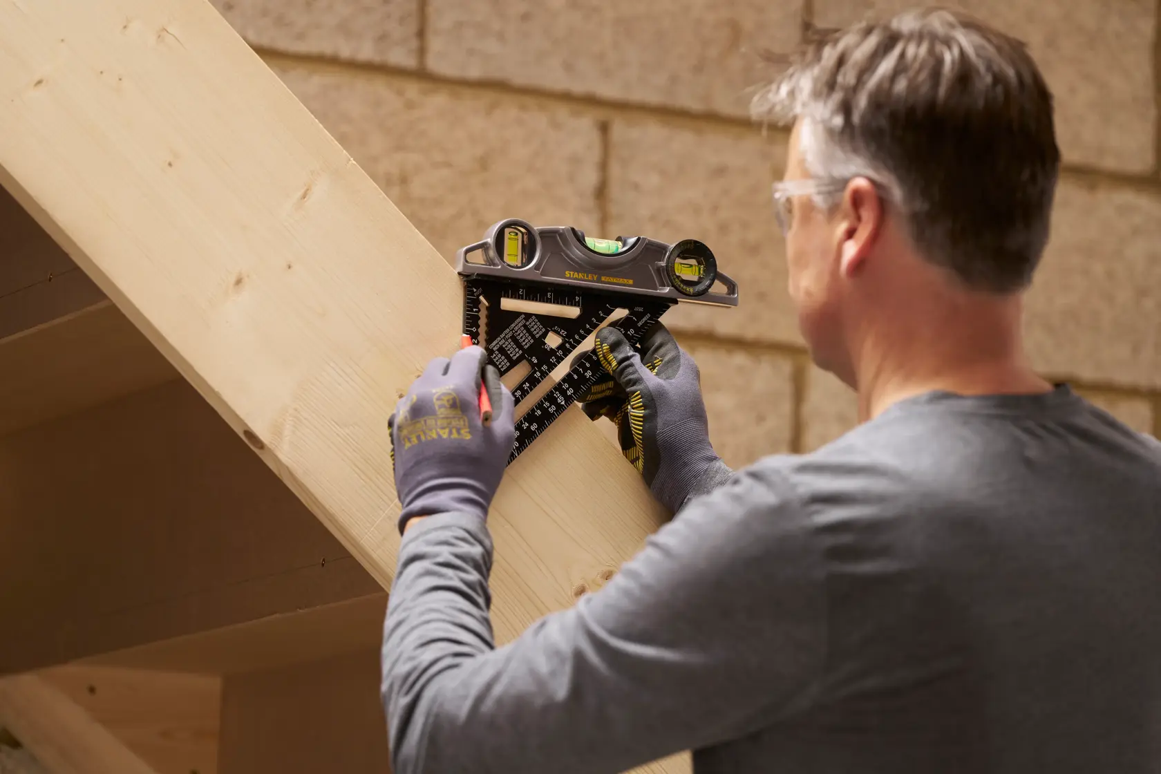 STANLEY STHT46104-0 layout tool in use for marking an angled wooden beam, shown in workshop setting.