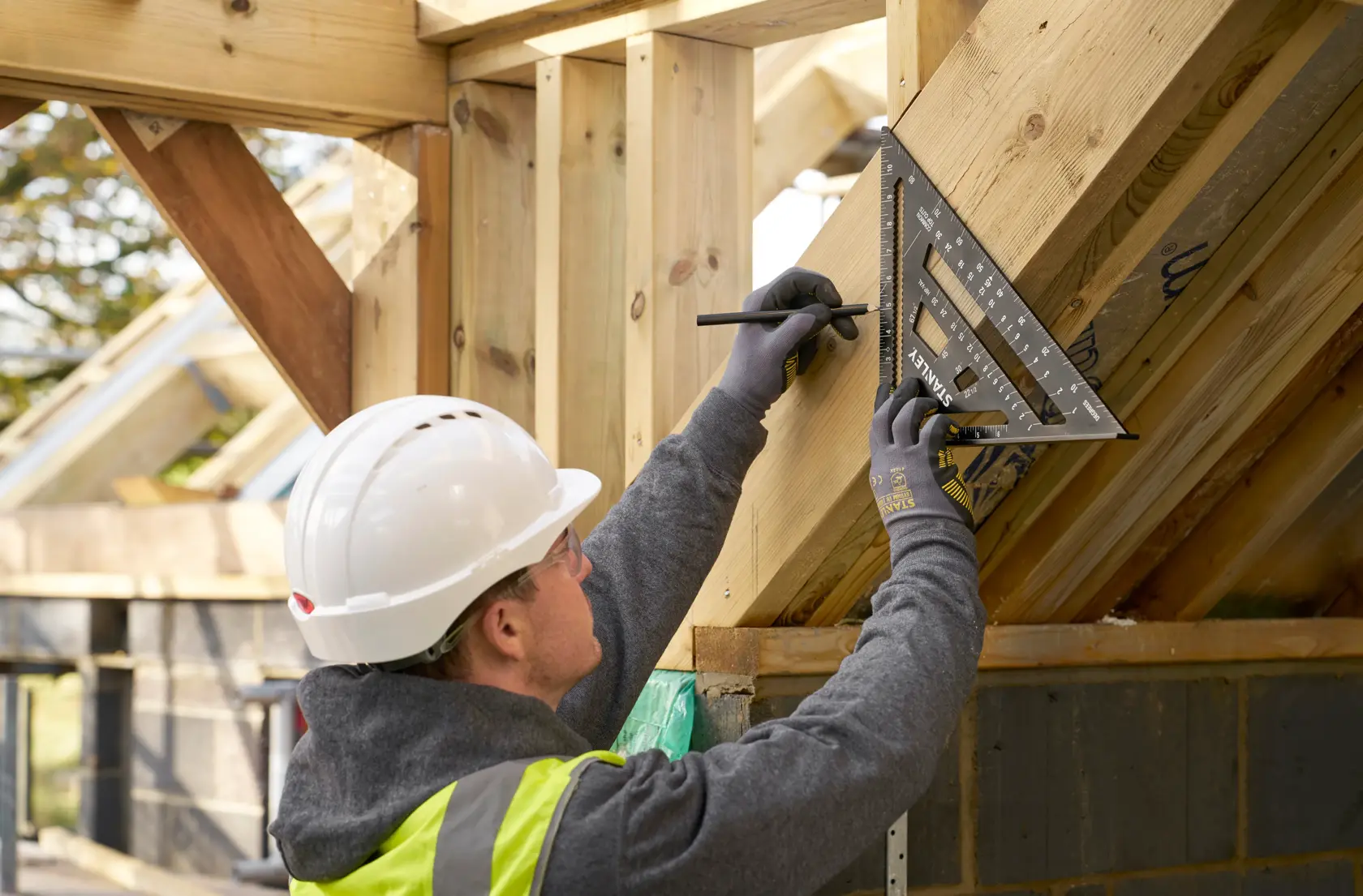 STANLEY STHT46105-0 rafter square used to mark timber angle on construction site.