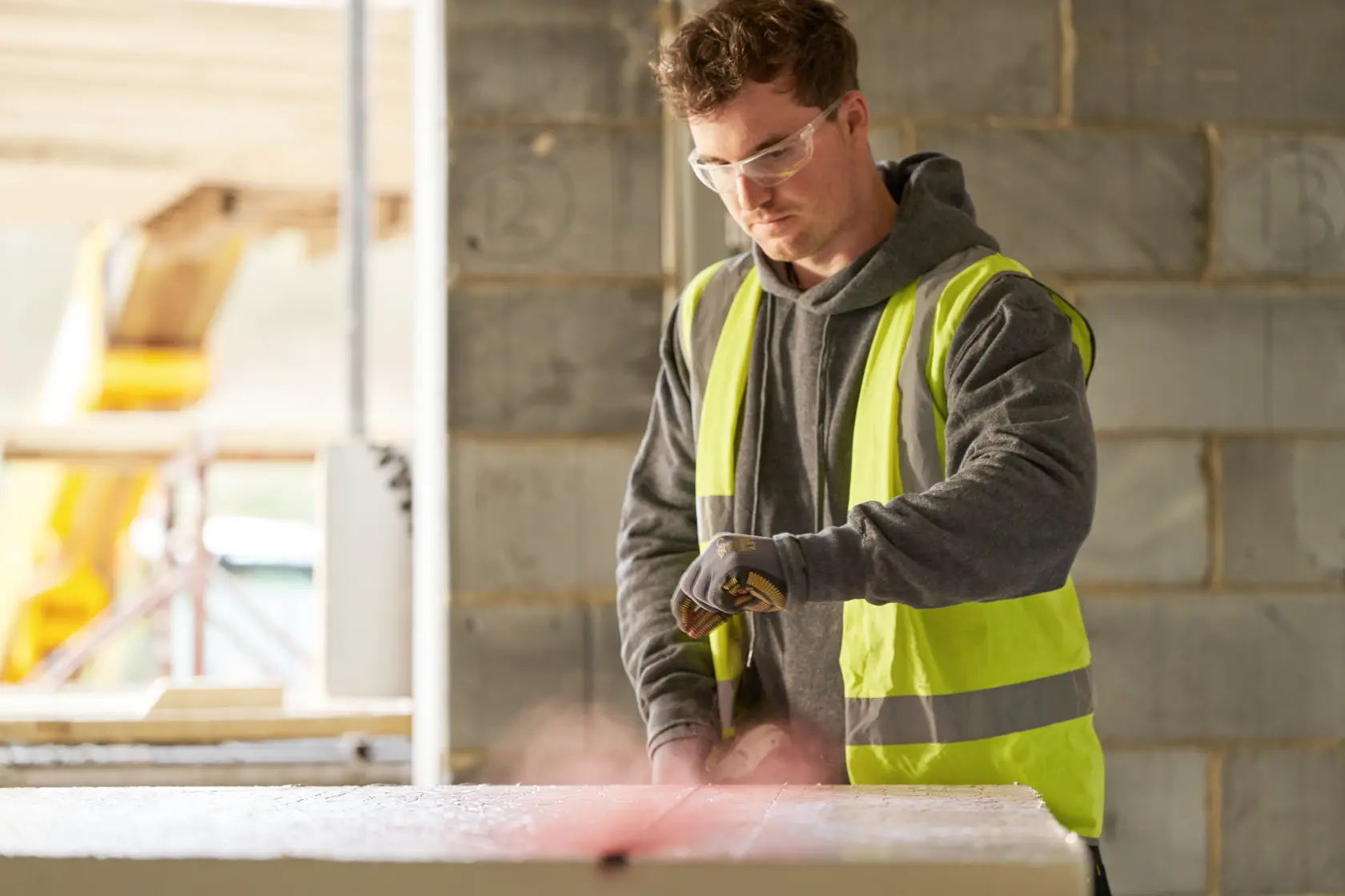 STANLEY STHT47611-0 photography of construction worker in hi-vis vest using tool at building site.